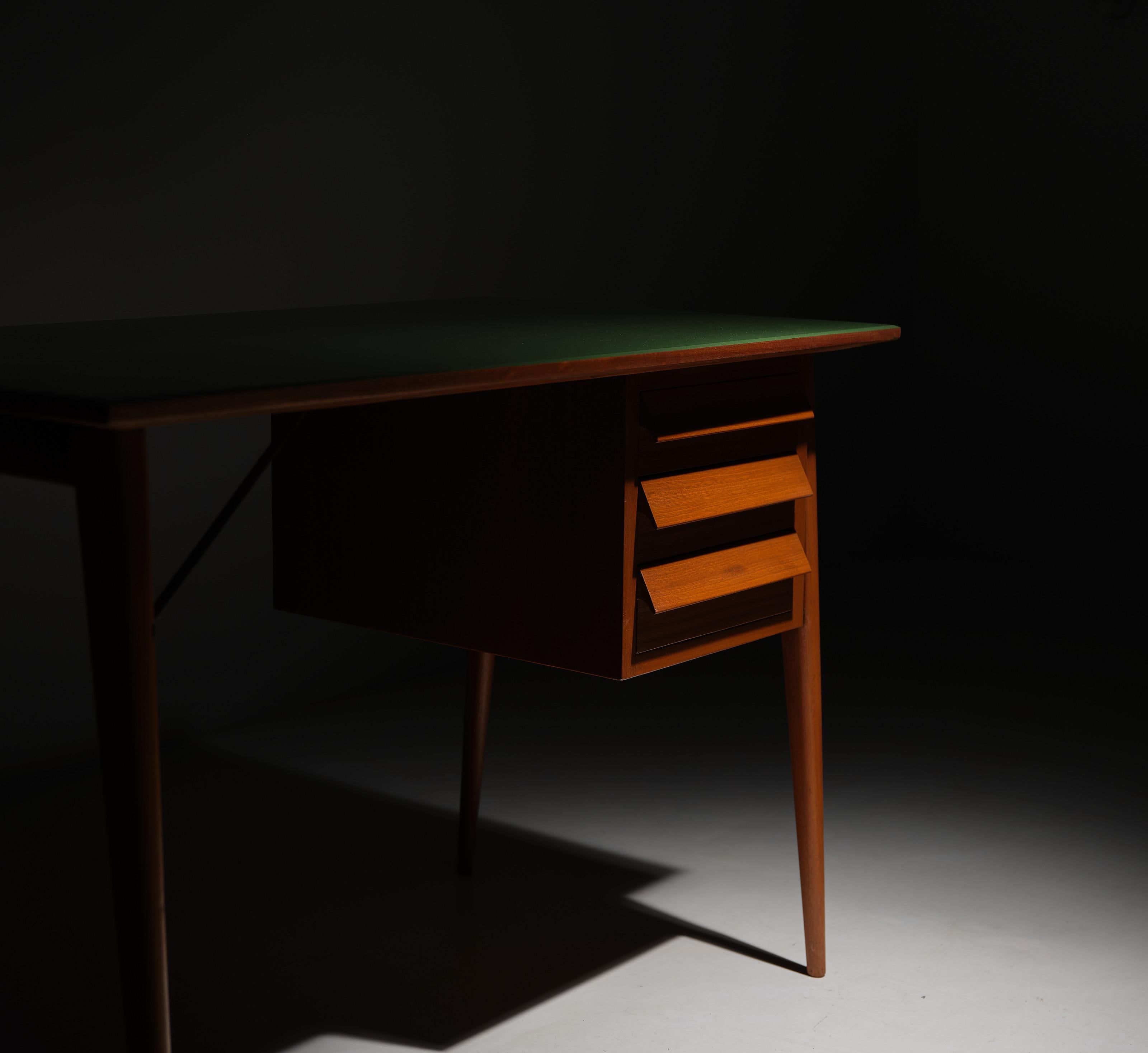 Enhance your workspace with this exquisite Midcentury Modern desk. Crafted entirely from premium teak wood, this desk features three spacious drawers for convenient storage. The standout feature of this piece lies in its expertly applied green