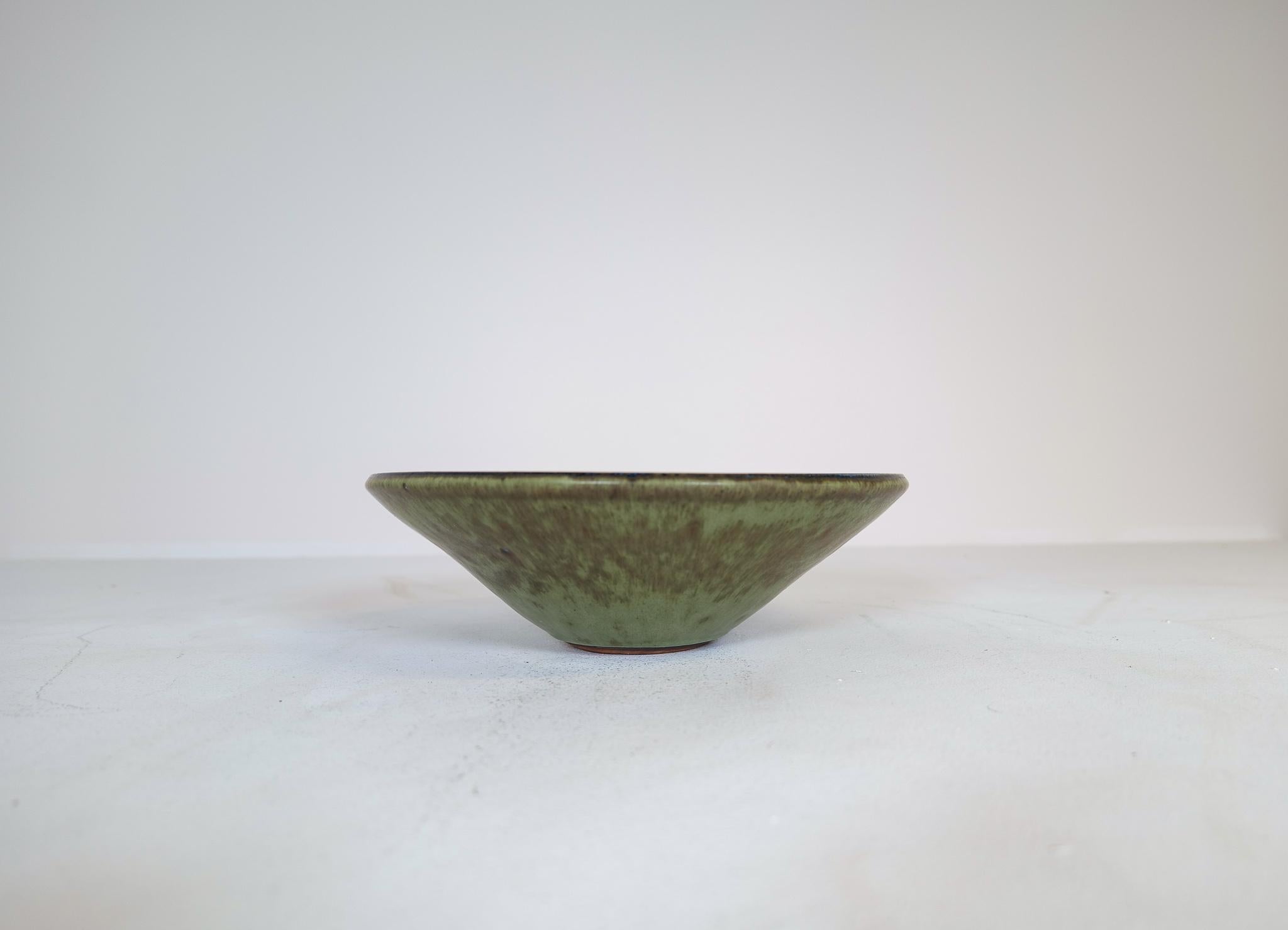 This large unique bowl has a wonderful glaze. It’s made in Sweden at R�örstrand and designed by Carl-Harry Stålhane. There is only one of its kind and is therefore a spectacular piece to have. Its stunning in its design and deep glaze pattern. Signed