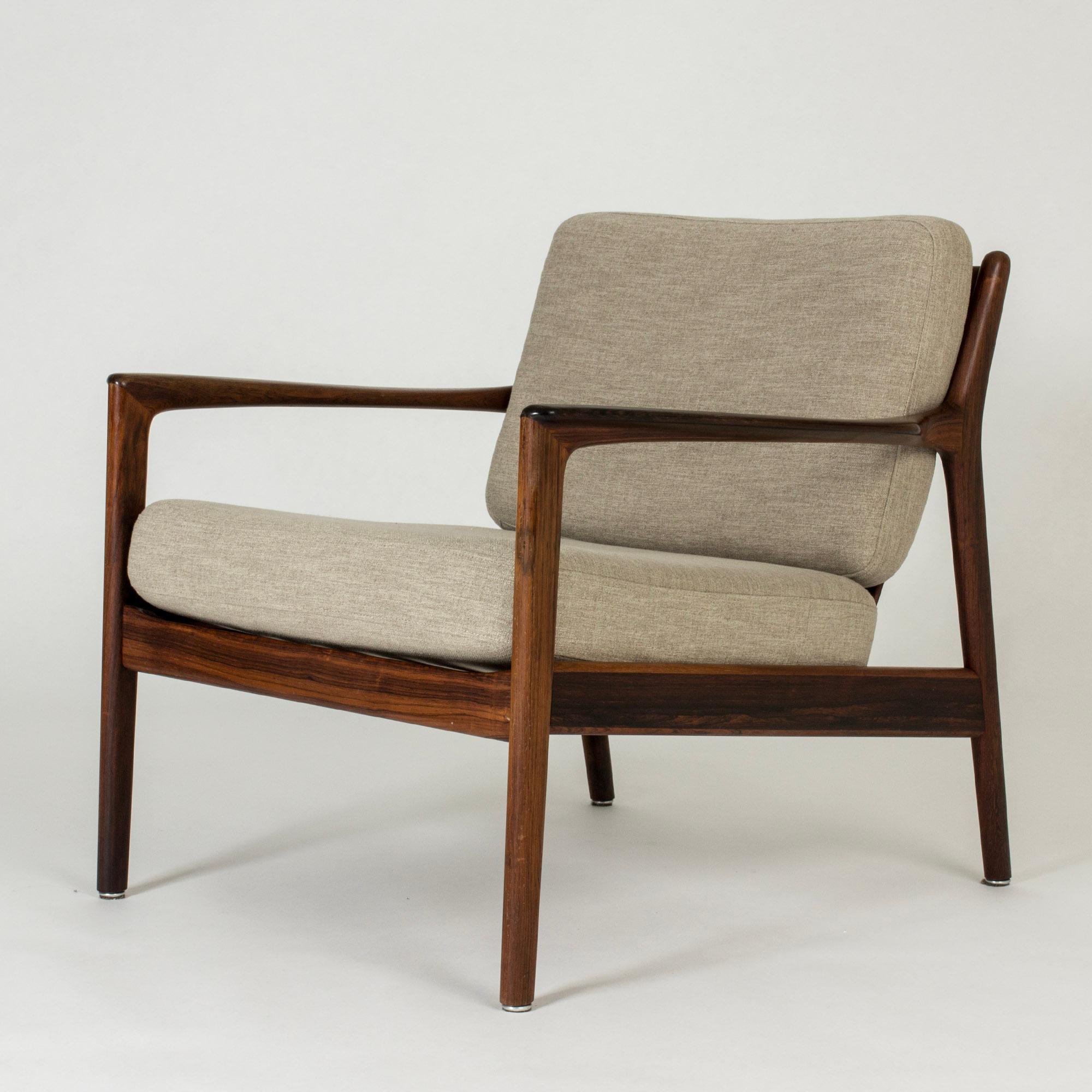 Elegant and comfortable “USA 75” lounge chair by Folke Ohlsson, with loose greige cushions. Rare rosewood version. Beautifully sculpted armrests and ribbing in the back.