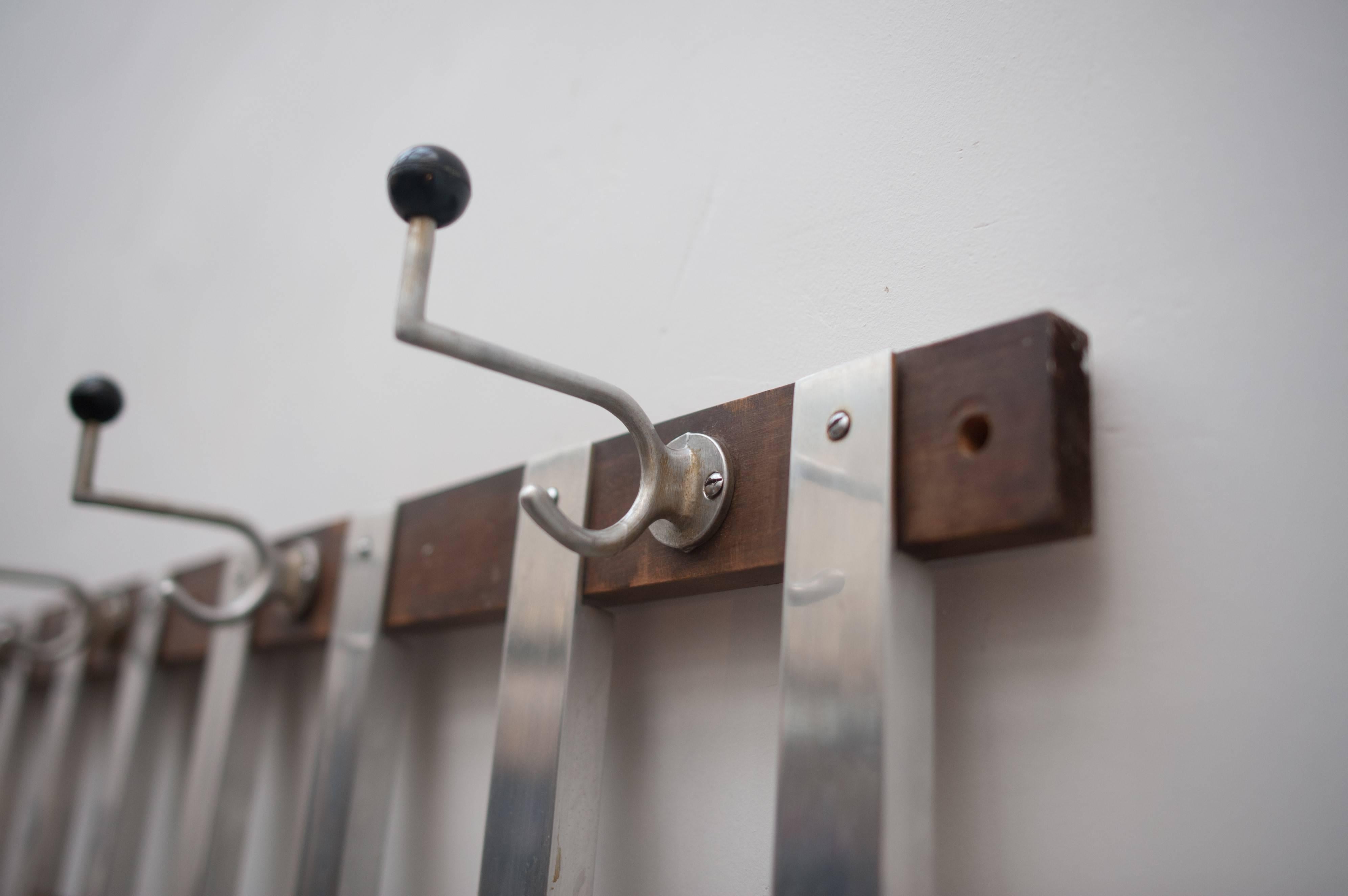Large wall-mounted constructivist coat rack in aluminium combined with solid wood.
 