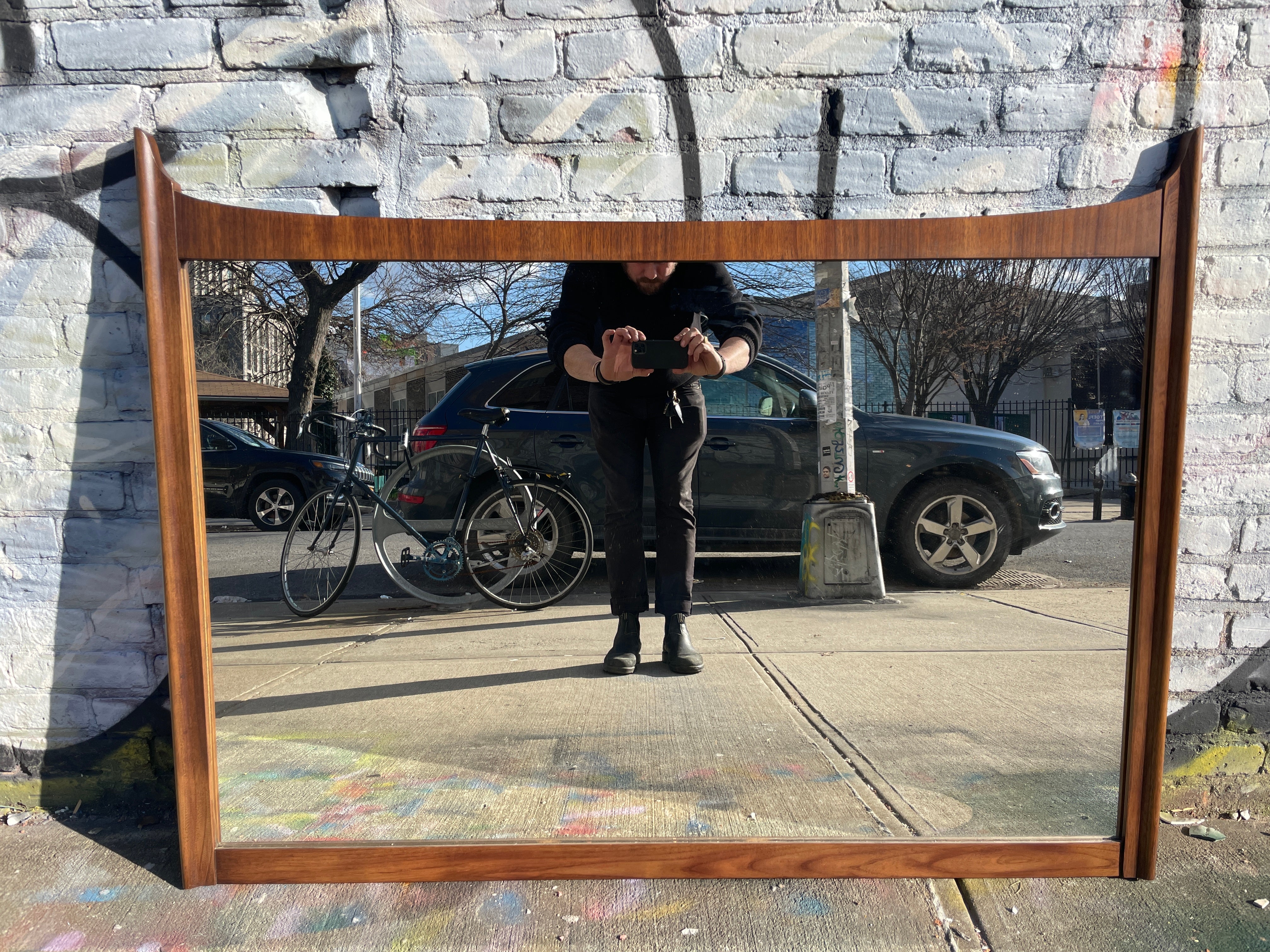 This wonderful Mid-Century Modern solid walnut mirror. No label. Will come with wire, wired to hang horizontal. Beautiful vintage condition and great high quality woodworking. Finished back. Solid and heavy. In style of Adrian Pearsall. Made in
