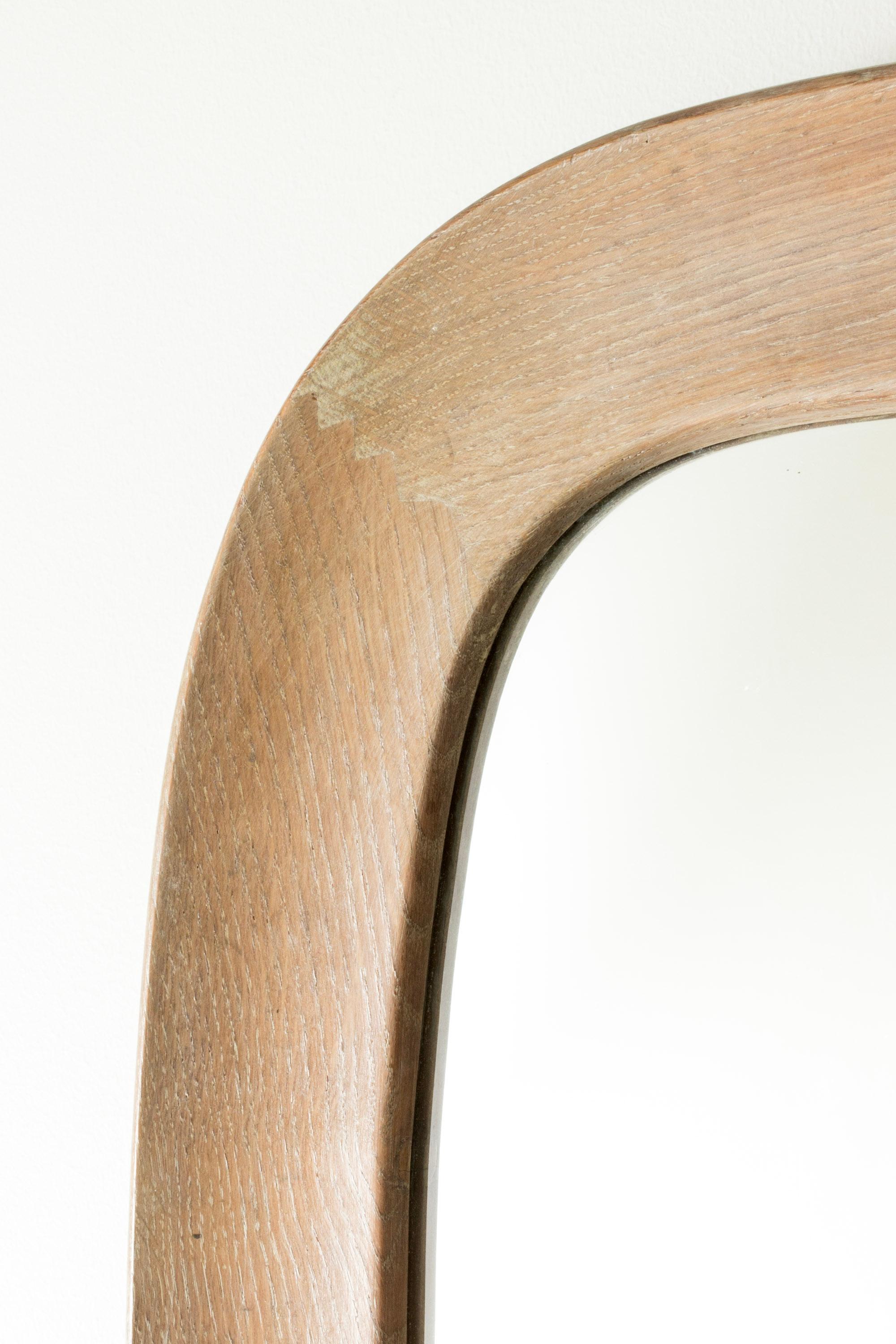 Stylish Swedish midcentury wall mirror, with a wide washed oak frame. Appealing, rounded design.
