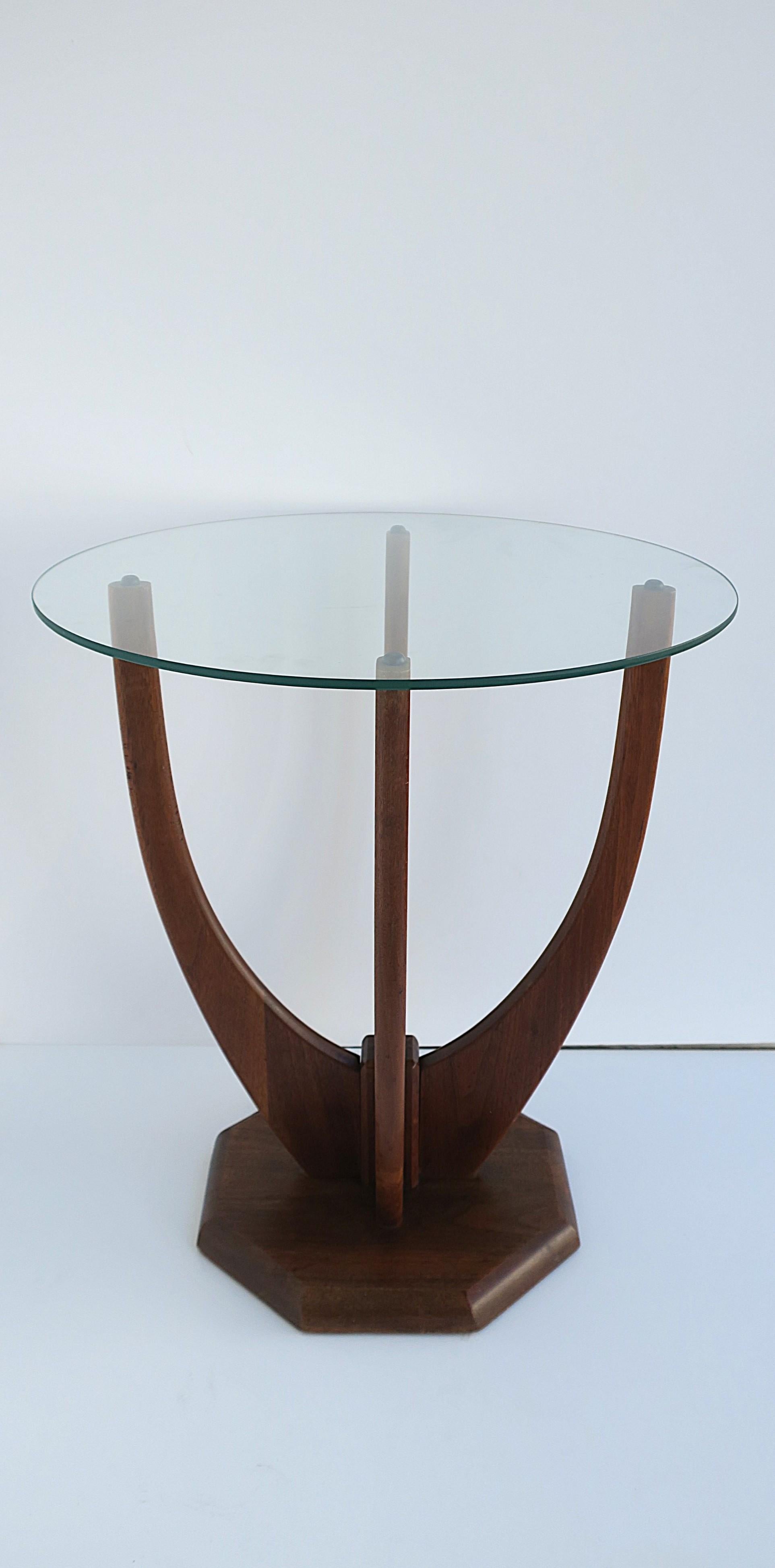 An elegant sculptural walnut wood and glass side or end table, Midcentury Modern design, circa mid-20th century. Table has a walnut wood branch-like design with an octagonal base (nice alternative to round), finished with a round glass top. Table is