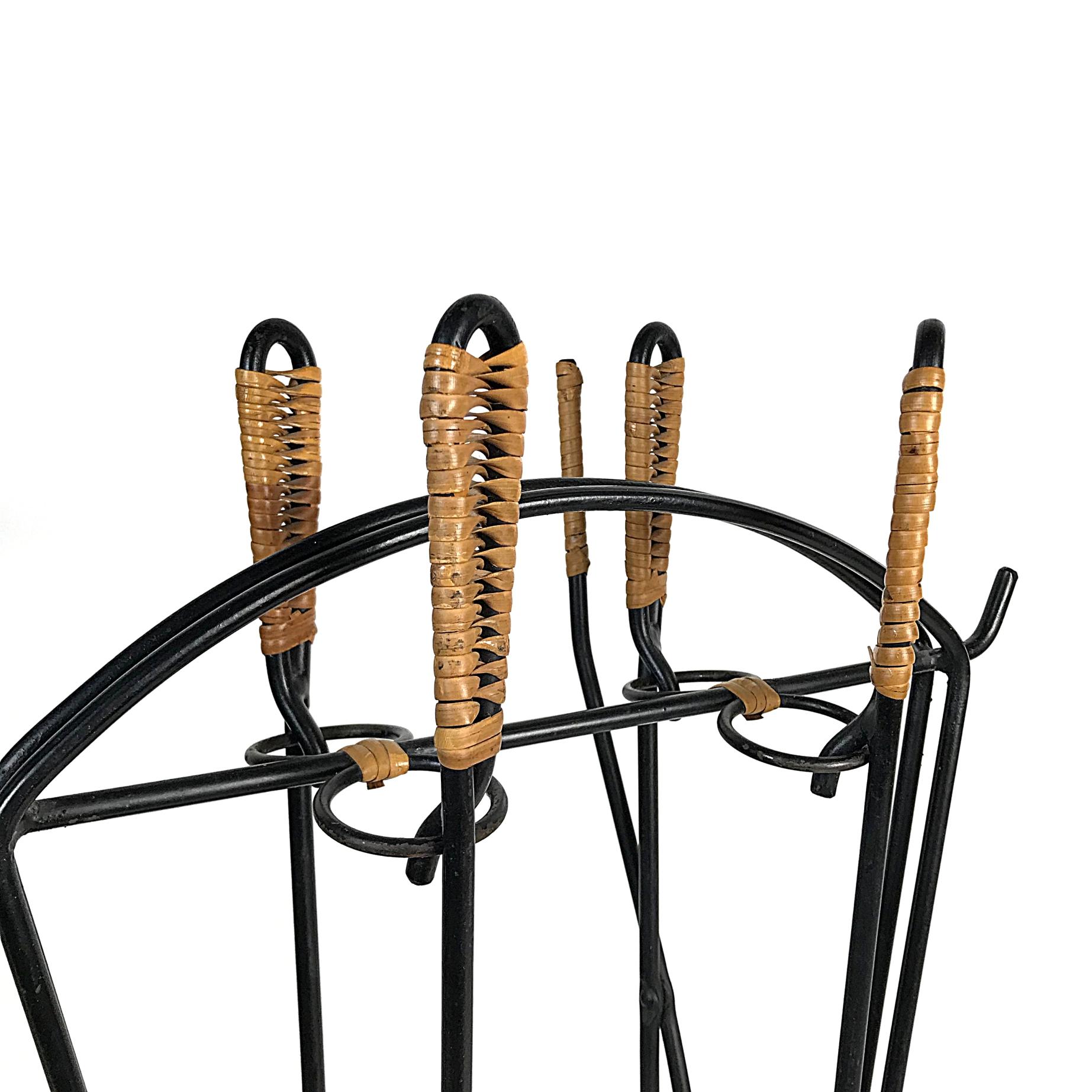 Simple and elegant midcentury fireplace tools in the style of Carl Auböck manufactured in the 1950s, Germany. Black lacquered wrought iron with woven rattan handles. The set is in excellent condition.