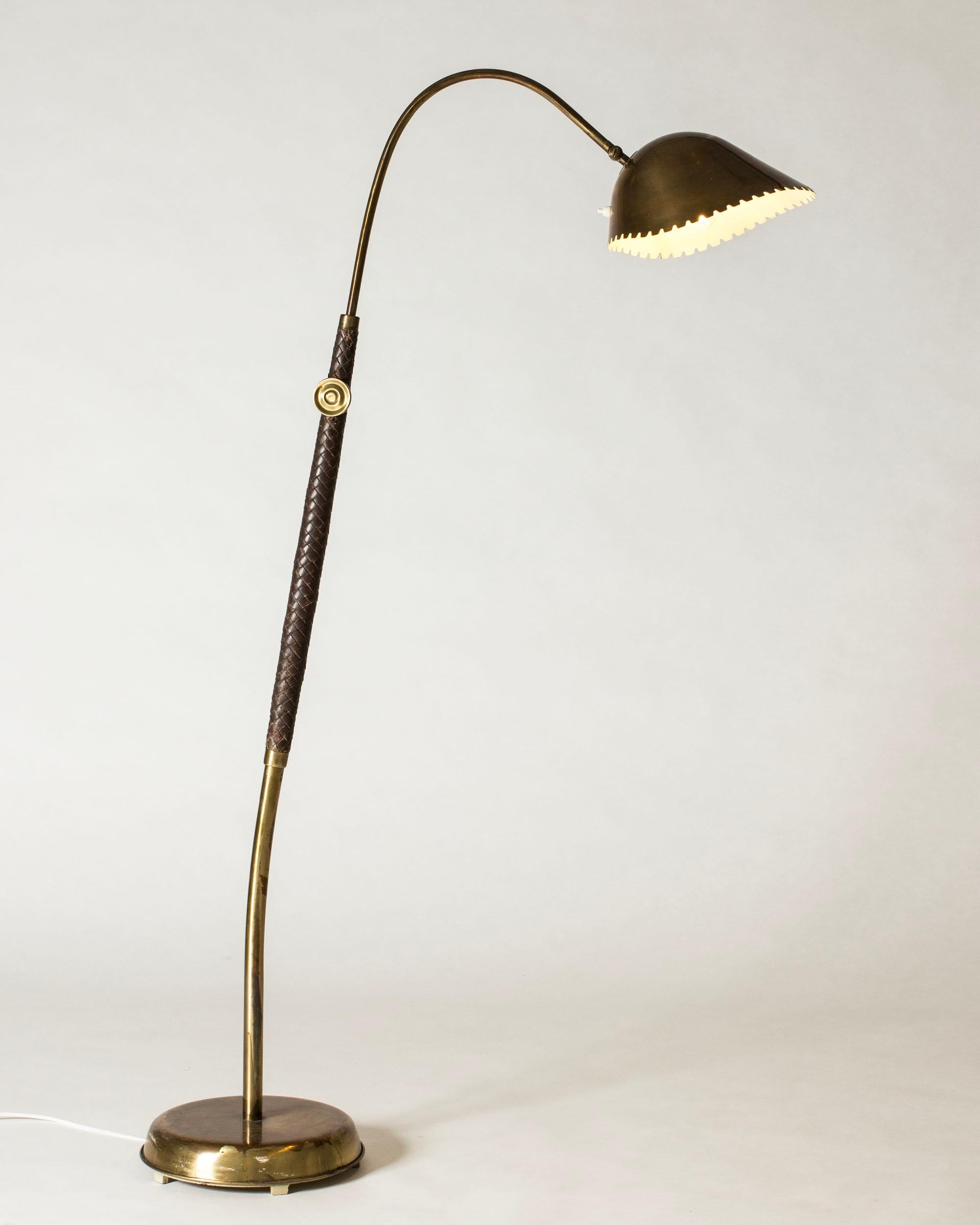 Striking modernist floor lamp from ASEA, in a luxurious design in brass and leather. Stem partially dressed with leather, decorative screw mechanism for adjusting the height from regular to a very tall height. Shade with a scallopped edge.

A