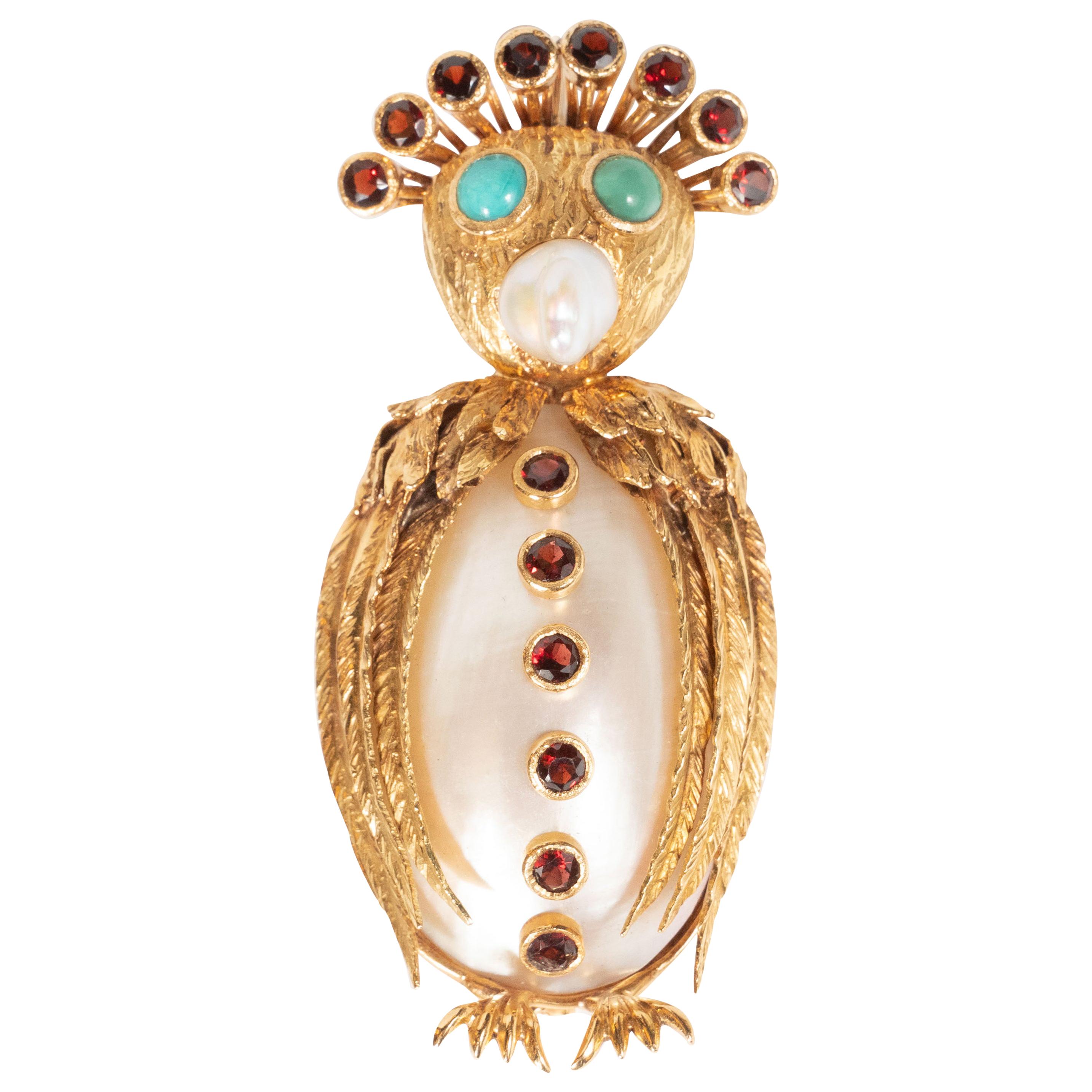 This dazzling and whimsical owl brooch features a nacreous mollusk body adorned with six Campari hued garnet 