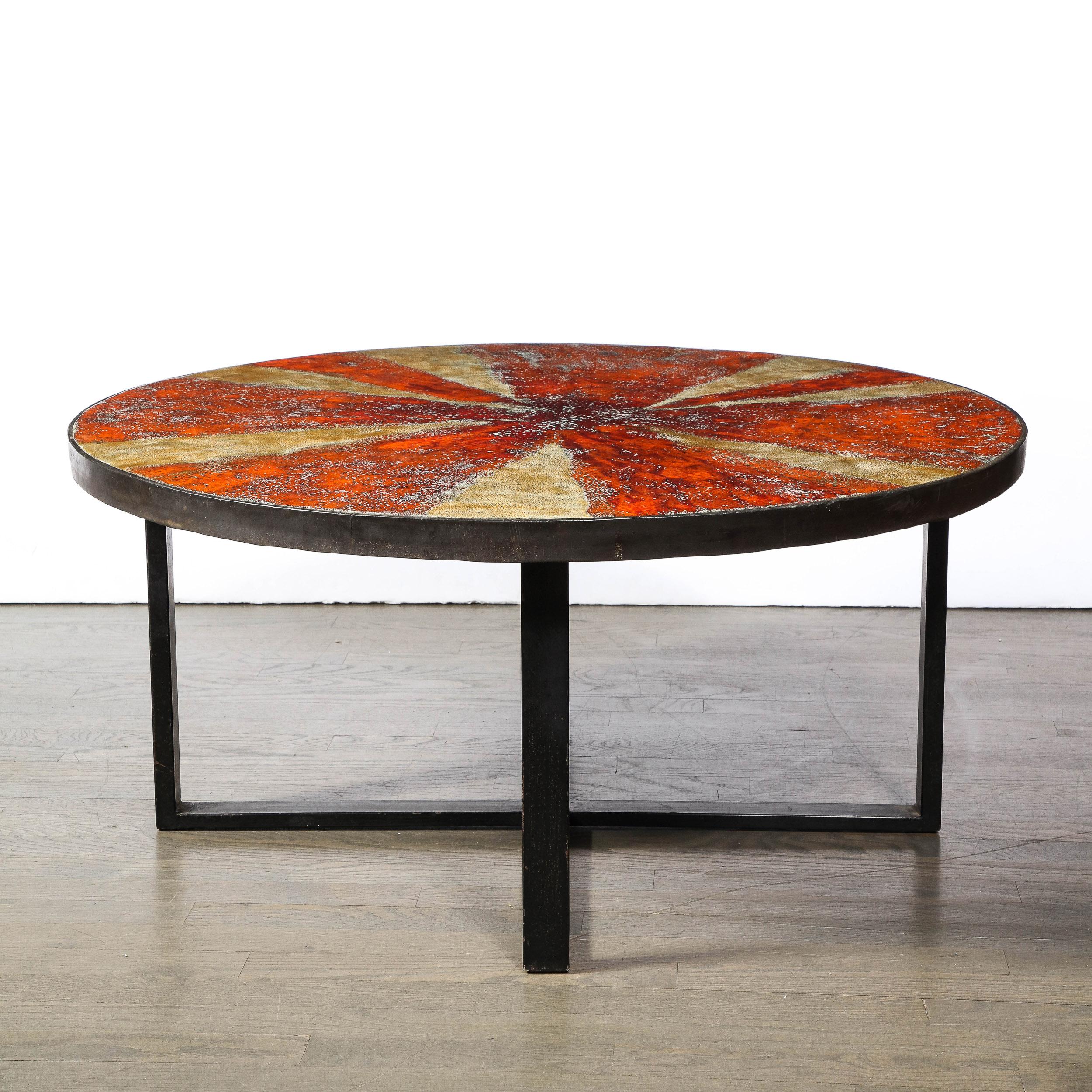 This refined Mid-Century Modern ceramic cocktail table was realized by the esteemed G. Olivier in Switzerland circa 1960. It features a starburst pattern enameled ceramic center with a lava glaze consisting of alternating tones of mottled tan and