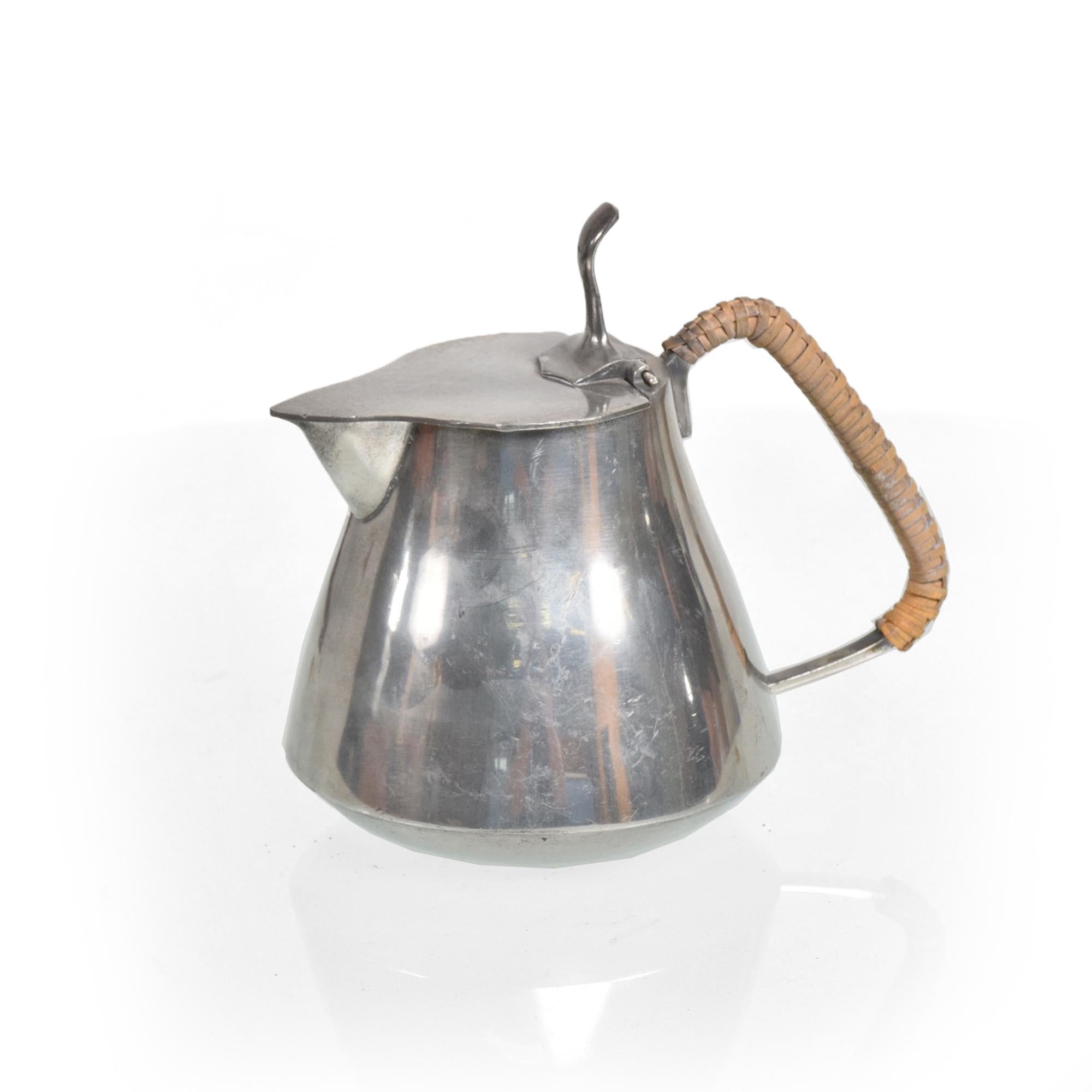 Just for you: Fabulous Mid-Century Modernist handcrafted pewter creamer pitcher accented by a striking rattan wicker handle crafted by American artist designer craftsman, Fred Dodson of New Hampshire, 1960s, USA
Dimensions: Height 5 in. (12.7