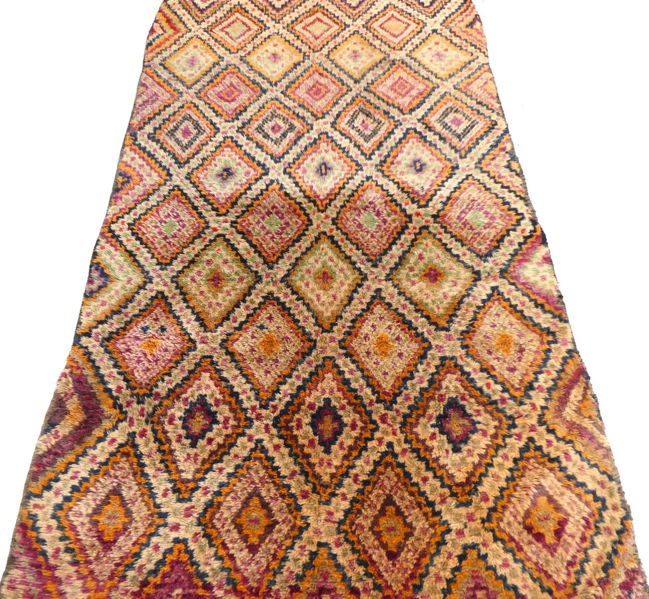 Midcentury Moroccan Beni M'Guild rug handwoven with ombre shades of  green, indigo, magenta, orange and ivory wool in a complex Berber diamond pattern. Excellent condition, circa 1970.

Dimensions: 6'3 X 12'

Beni M'Guild rugs are hand-knotted by