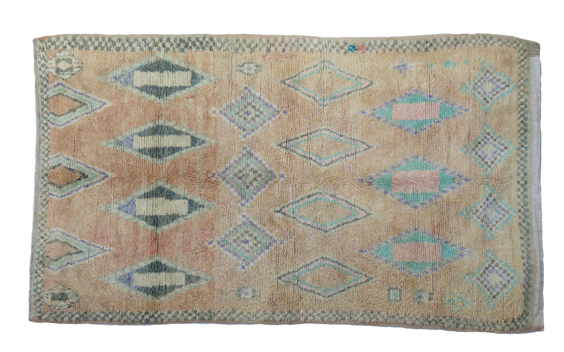 Circa 1980 Tapis Boujad marocain tissé à la main avec des tons de laine miel, gris, bleu et menthe dans un motif abstrait de symboles berbères enivrants et de bordures en damier.
Dimensions : 6 x 10'6 