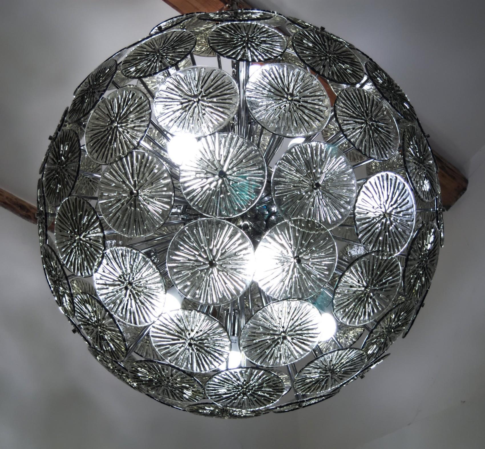 Perfect sphere created by almost 100 elements of gray acciaio glass. Each element is hold by a chrome metal rod to recreate a perfect sphere. Two available to match in a large living room.

There are 12 standard sockets/bulbs to give the right