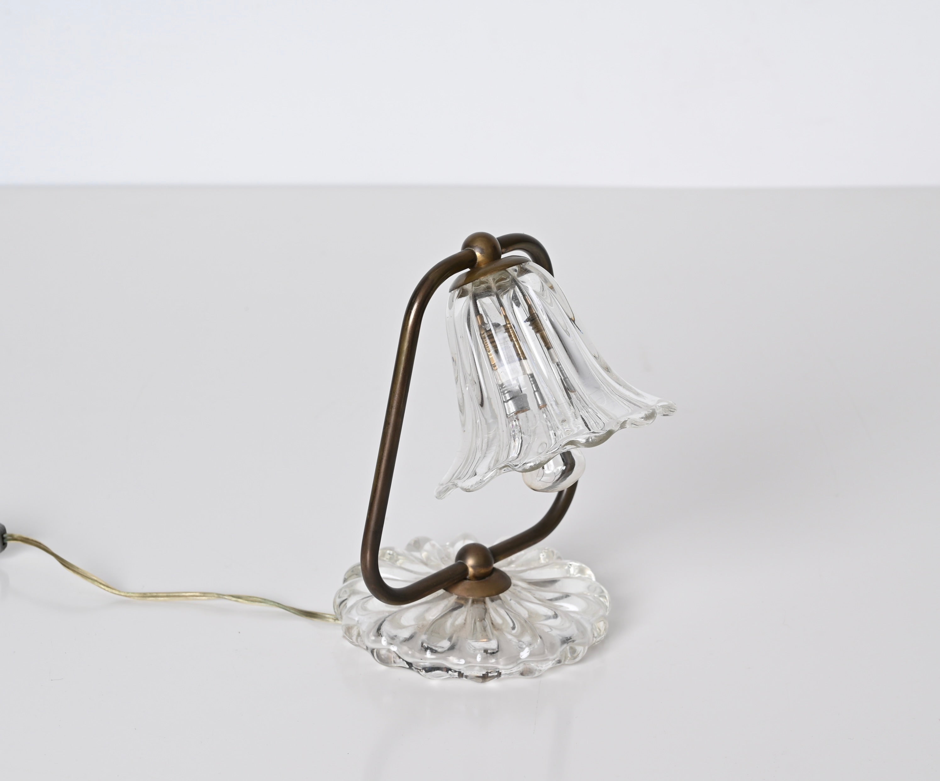 Gorgeous bell shaped table lamp in Murano glass and brass. This romantic table lamp was made in the early 40s in Italy and is attributed to Carlo Scarpa.

This finely crafted lamp recalls the the shape of a bell in motion. The base and the
