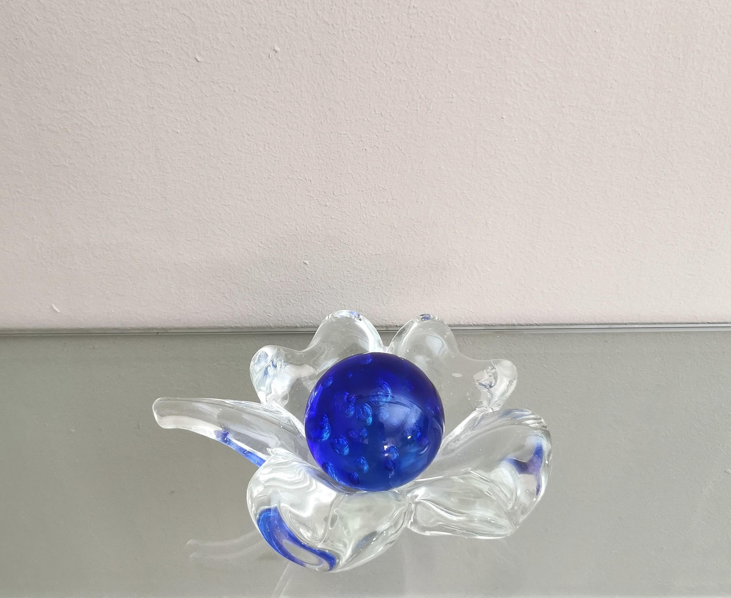 Decorative object produced in Italy in the 70s attributed to the italian designer Flavio Poli.
This object was made of transparent Murano glass in the shape of a flower, with a blue Murano glass 