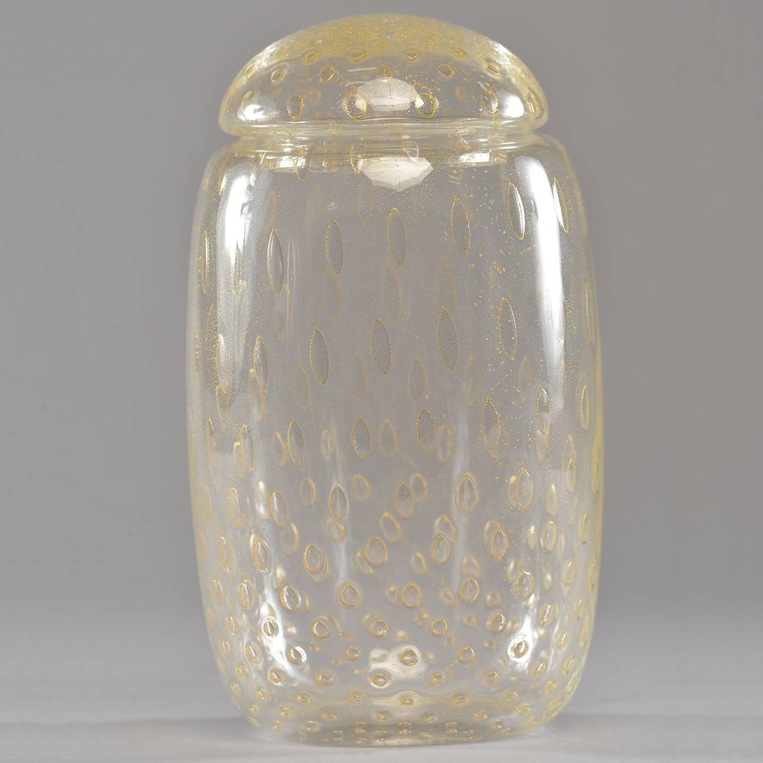 Haut récipient à couvercle en verre de Murano du milieu du siècle, en verre clair embelli d'inclusions dorées. Fabricant inconnu. Excellent état vintage, sans aucun défaut constaté. Petite usure superficielle éparse.