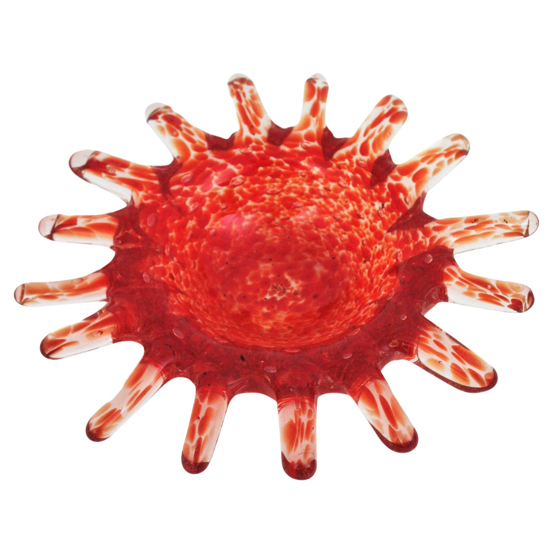 Sunburst Murano glass bowl or ashtray, orange, red and clear glass. Italy, 1960s
Spotted decorations in shades of orange in a clear background with air bubbles.
Use it as vide-poche, ashtray, or decorative bowl. Place it alone or display it with