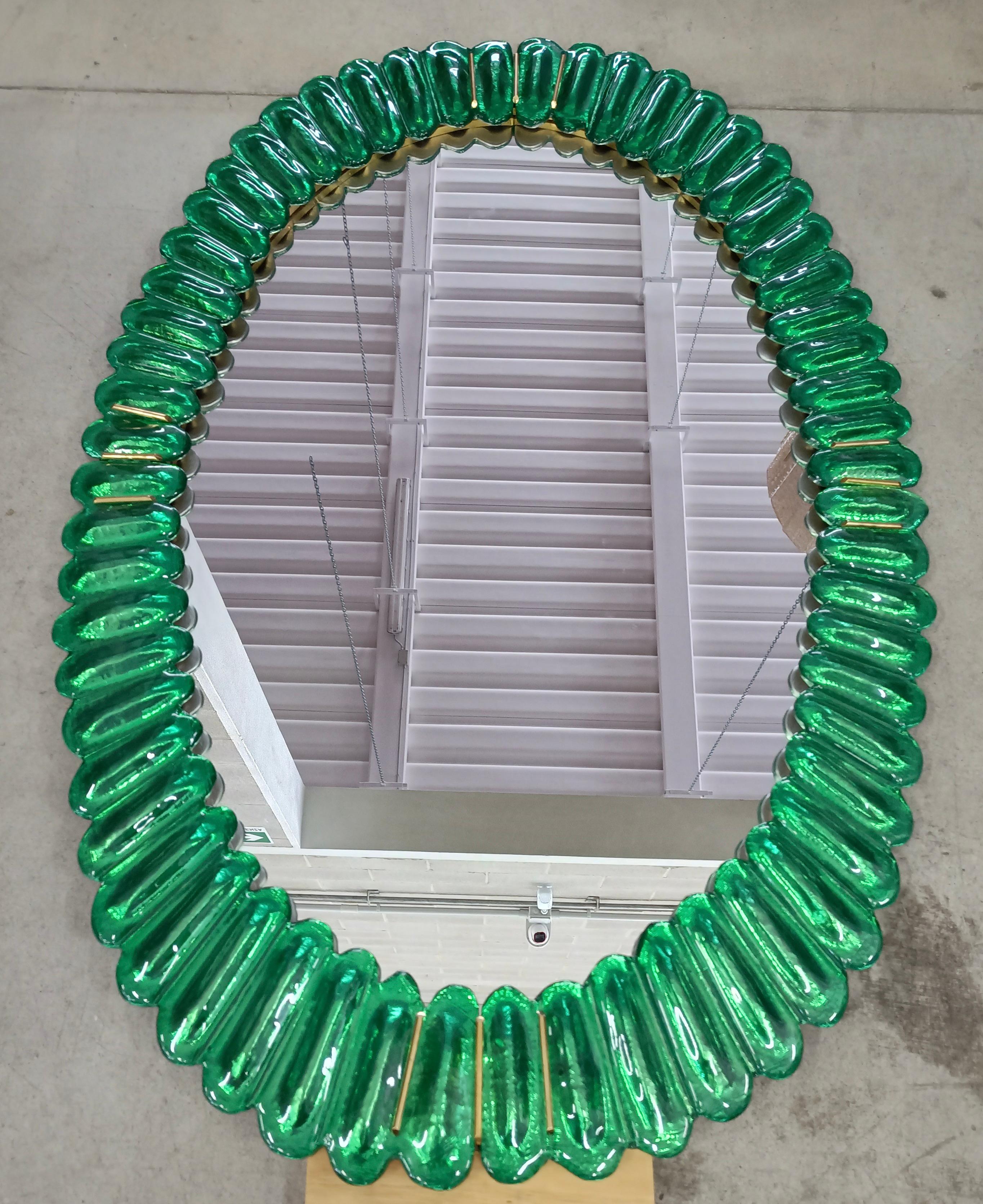 Atemberaubender Spiegel in leuchtendem smaragdfarbenem Murano-Glas, Venedig. Ein Spiegel, der allein Ihr Zuhause einrichtet.

Der Spiegel hat eine Rückwand aus Holz, auf der vier smaragdfarbene Murano-Glasteile montiert sind, die ein Oval bilden,
