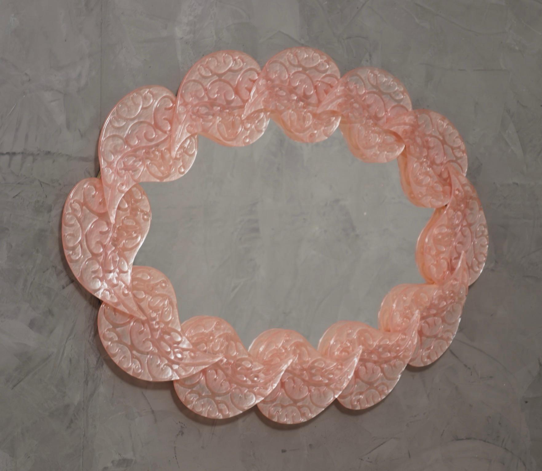 Magnifique miroir en verre de Murano rose flamboyant. Un miroir qui, à lui seul, meublera votre intérieur.

Le miroir a une structure arrière en bois, sur laquelle une série de feuilles en verre de Murano sont montées pour former un ovale comme on