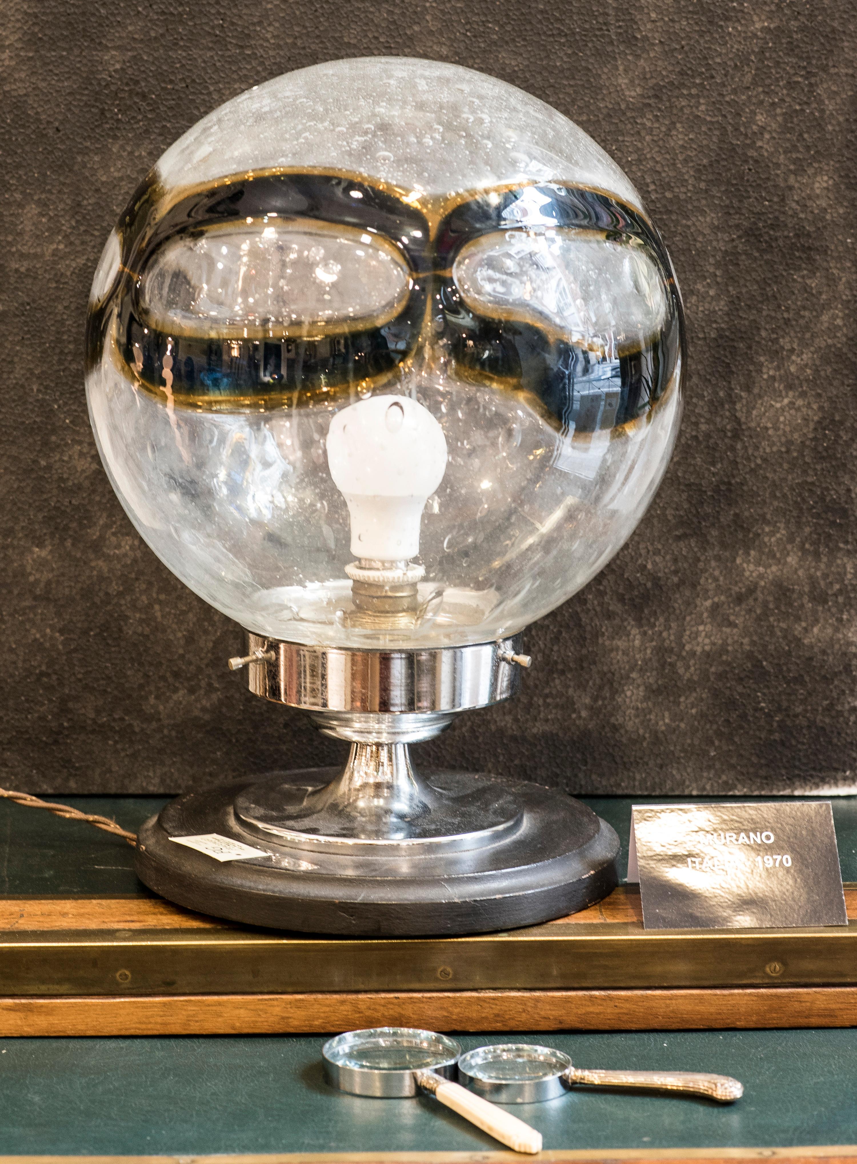 A funny and delightful Murano globe table lamp
In blown glass with a moderm design in blue and yellow color, with a steel foot and wooden base.
A beautiful touch of design for any room!!
