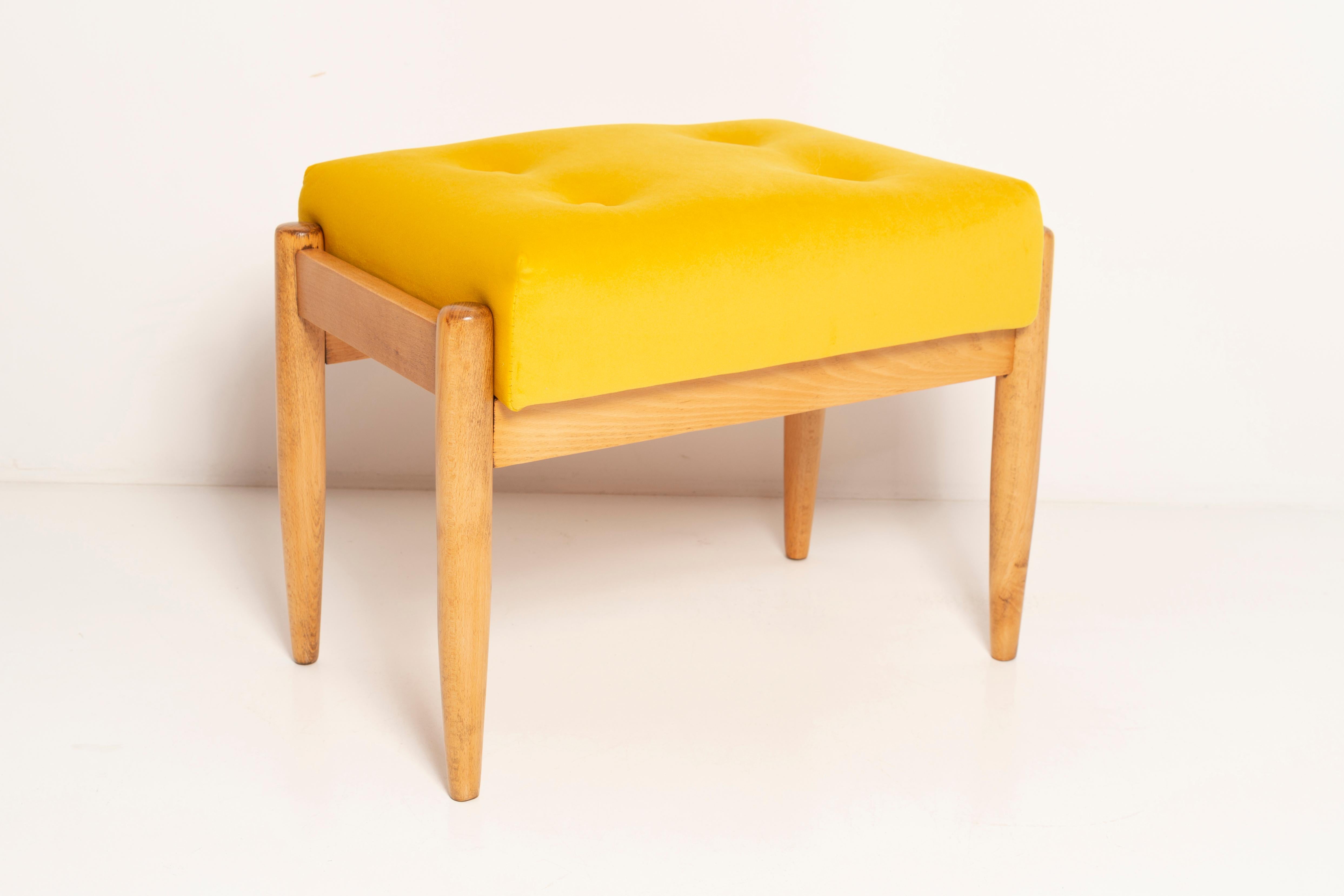 Tabouret du tournant des années 1960. Magnifique revêtement en velours de haute qualité de couleur jaune moutarde. Le tabouret est composé d'une partie rembourrée, d'une assise et de pieds en bois se rétrécissant vers le bas, caractéristiques du