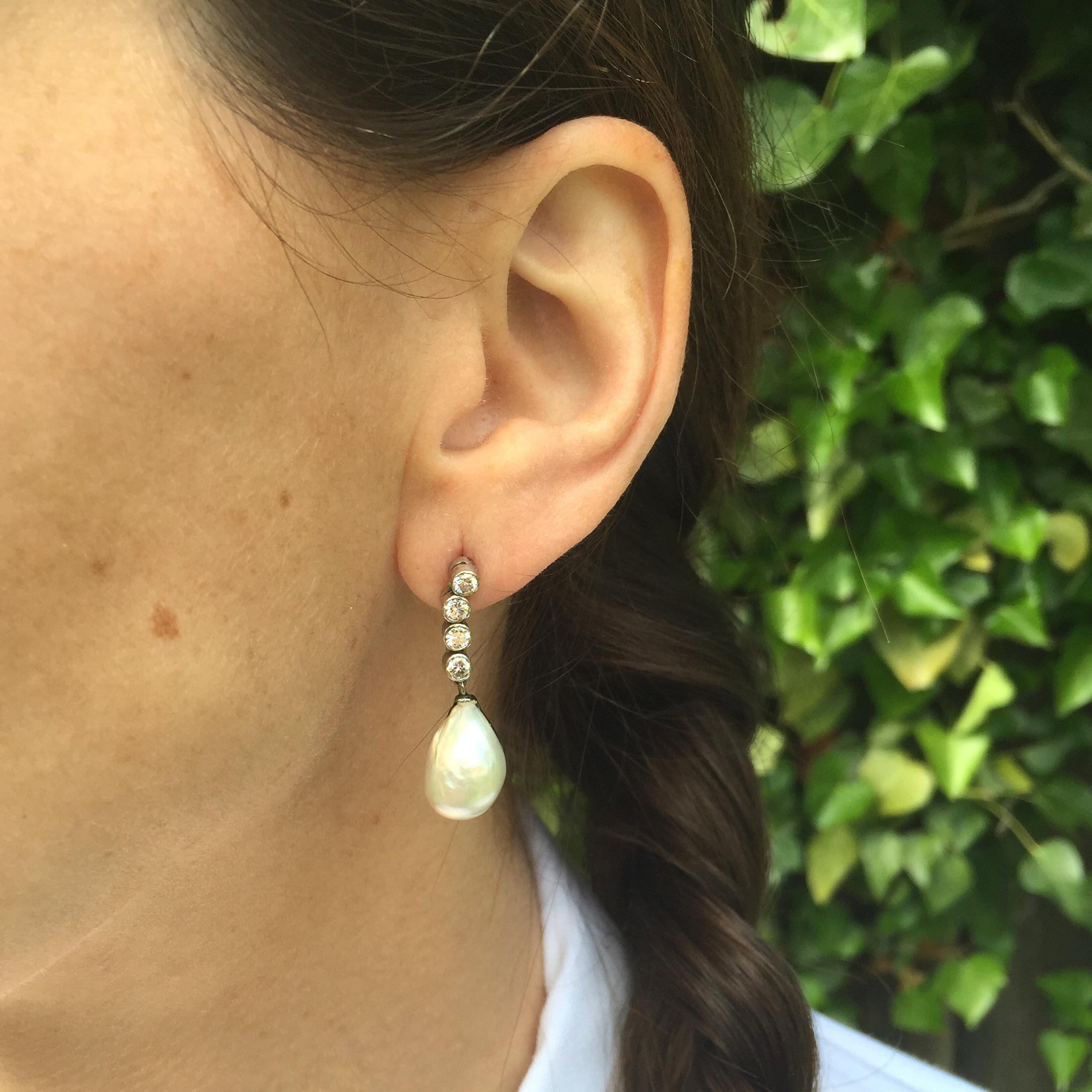 A truly phenomenal pair of earrings. A large pair of matching irregular drop-shaped natural saltwater pearls hang from an articulated line of brilliant cut diamonds. A rare and striking find that look fantastic when worn.

Accompanied by a Pearl