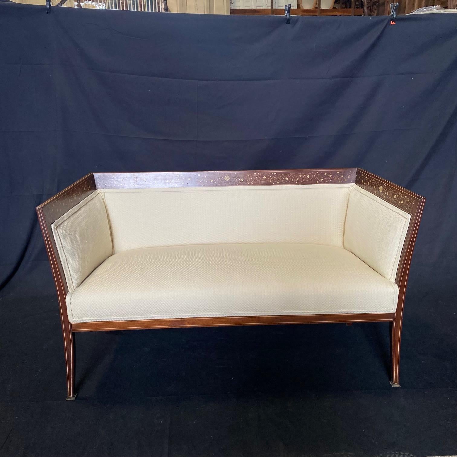 A lovely and well-proportioned inlaid sofa or loveseat with straight back and sides,  graceful lined tapered legs in mahogany embellished with inlays of berries, delicate flowers and foliage. Newly upholstered!  Beautiful from every angle.
#5966

H
