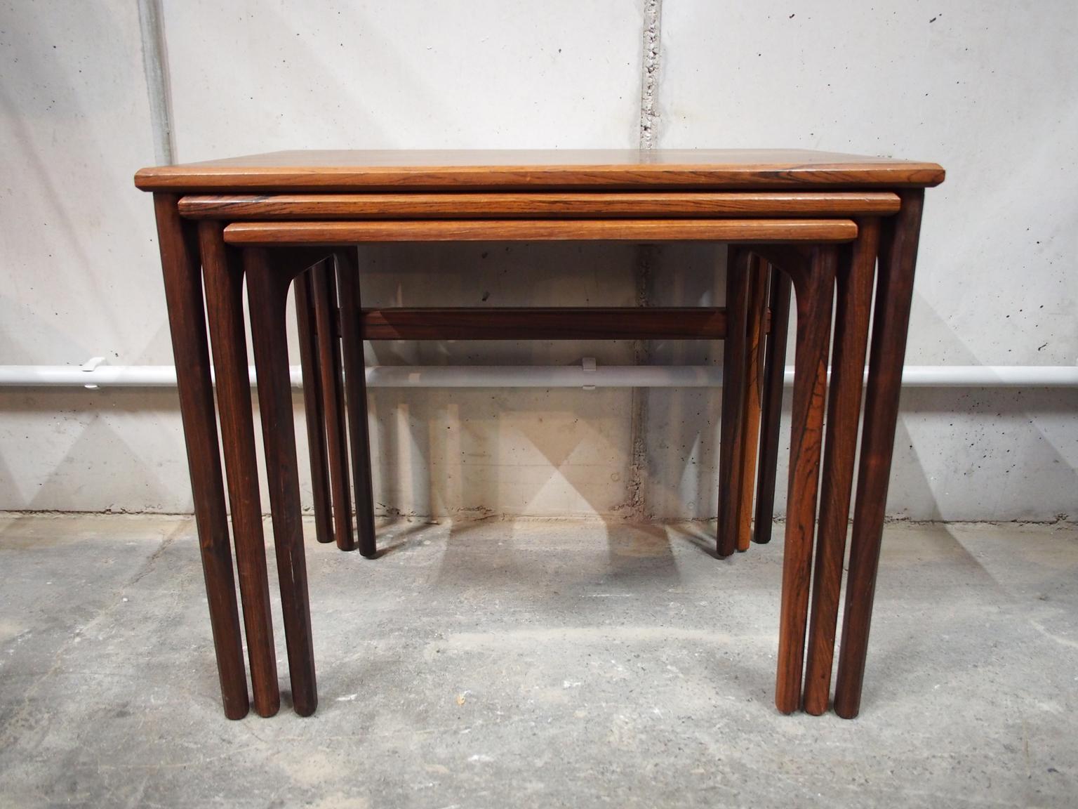A set of three Danish/Scandinavian Modern nesting tables made of rosewood or palisander, manufactured in midcentury, circa 1960.