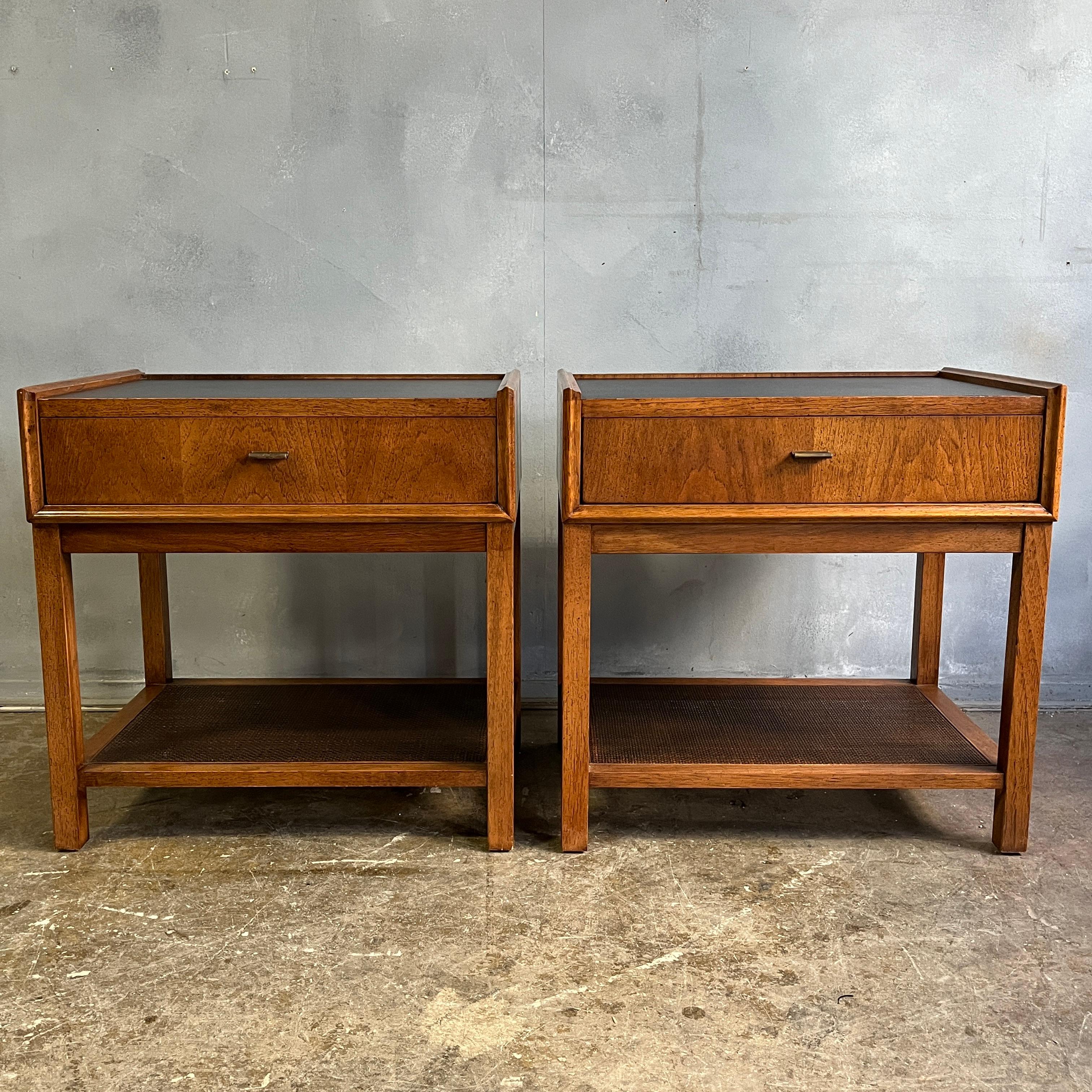 Beautiful and rare pair of nightstands / end tables designed by Jack Cartwright. Solid wood construction with brass pulls, cane shelf and grained leather top. Very solid and incredibly well crafted. In near flawless condition showing little use.
