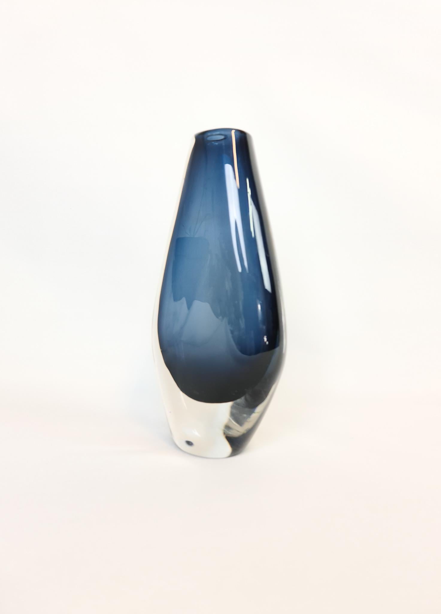 Wonderful large and heavy blue tinted vase, designed by Nils Landberg.
Wonderful glass with exceptional dark blue color that collaborates with the clear glass. 

Good vintage condition with some scratches.

Measures: H 25 cm, W 13, D 6 cm,