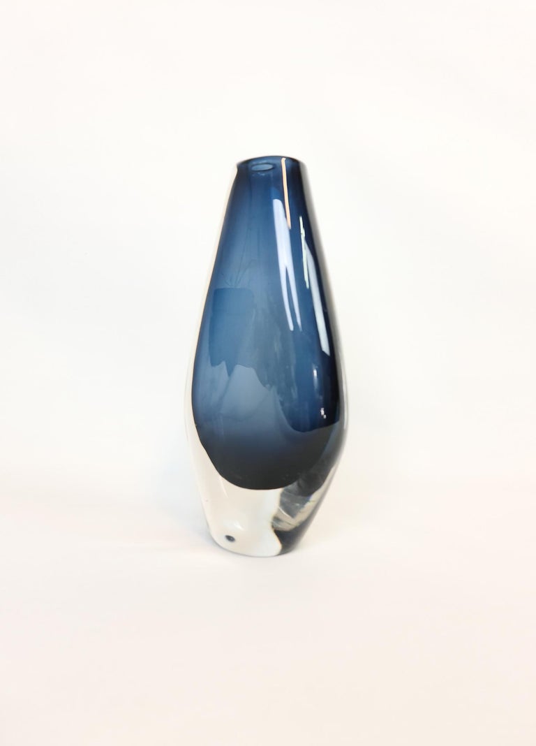 Wonderful large and heavy blue tinted vase, designed by Nils Landberg.
Wonderful glass with exceptional dark blue color that collaborates with the clear glass. 

Good vintage condition with some scratches.

Measures: H 25 cm, W 13, D 6 cm,