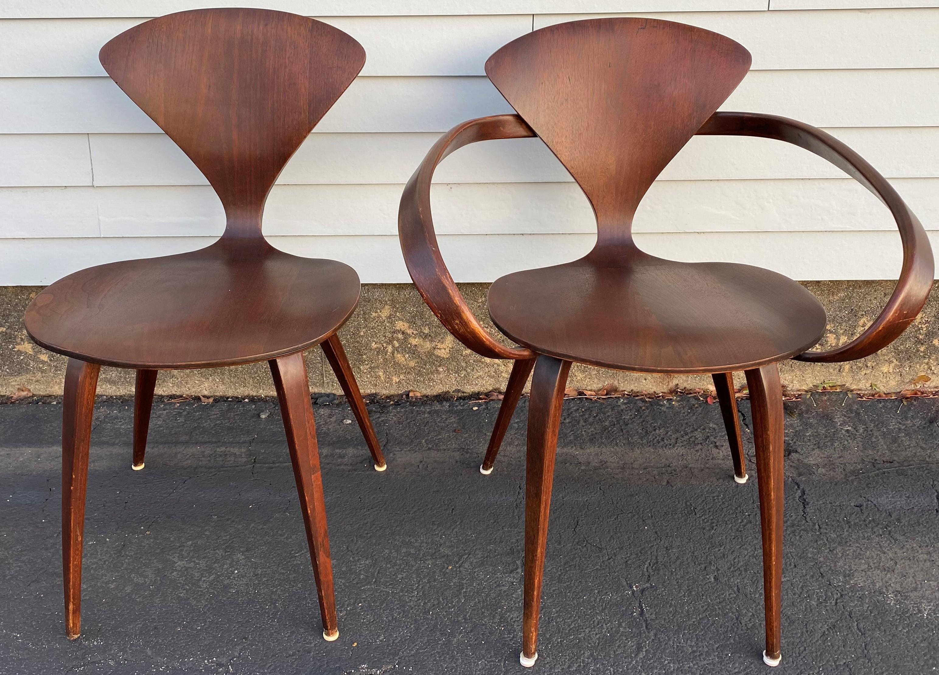 A nice midcentury set of five stylish pretzel walnut bentwood chairs, four side chairs and one arm chair, with round dining table with tapered legs, designed by Norman Cherner for Plycraft. The table is expandable, but no leaves are included. The