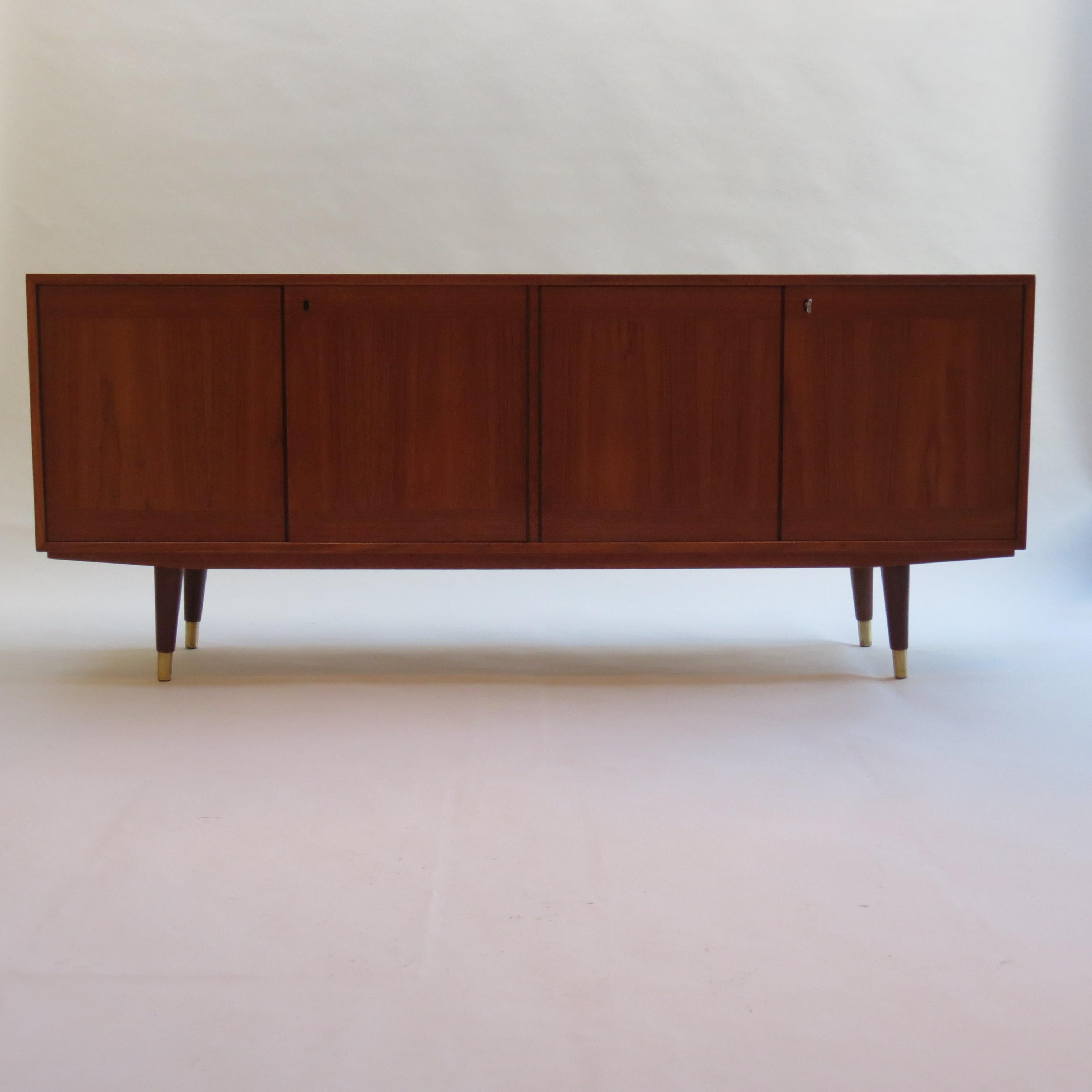 Midcentury Teak sideboard designed by Fredrik Kayser and manufactured by Gustav Bahus, Norway. 

Teak veneered case and doors with contrasting interior in Deal. Four opening doors reveal a removable shelf to one side and 3 internal drawers with