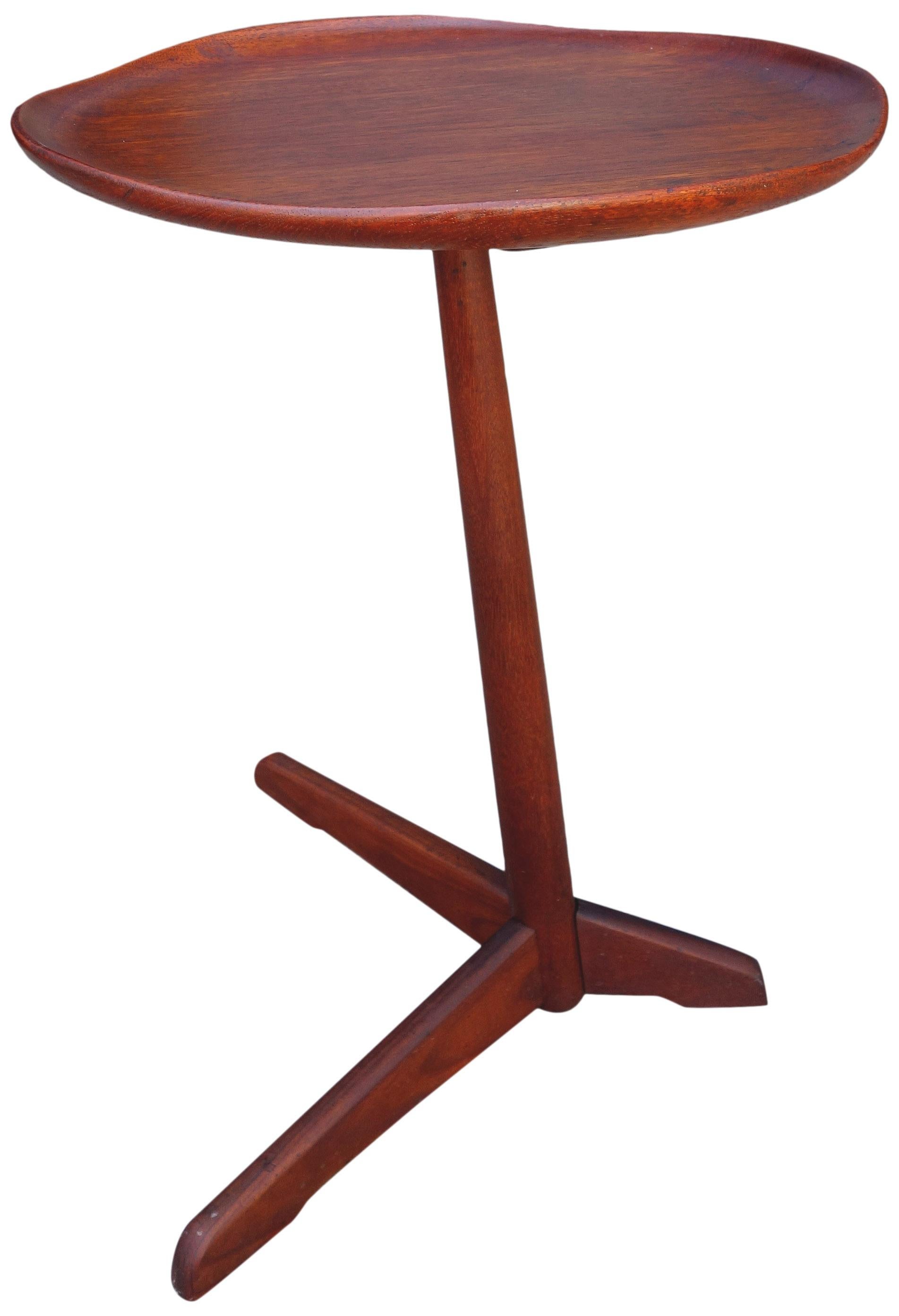 For your consideration is this amazing side table made in Norway produced by Steen and Strom. A cantilevered designed side table with a solid turned teak post and an irregular and raised edge tabletop. A three legged forked base supports the table.