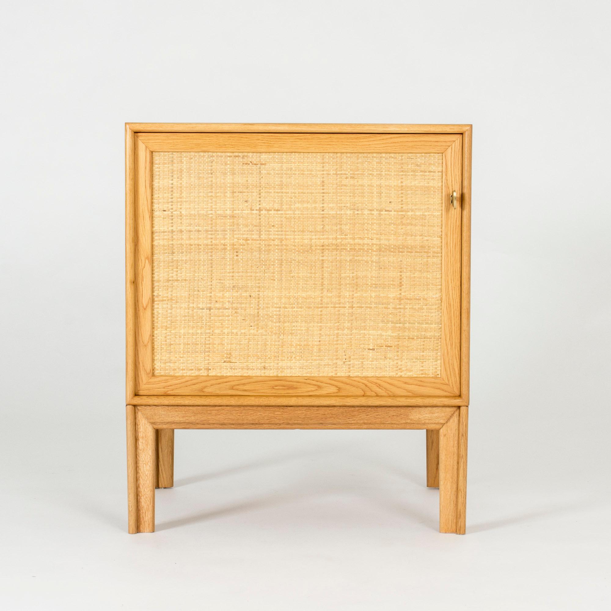 Neat oak cabinet by Alf Svensson. Made with a beautiful rattan front and with a large brass key.