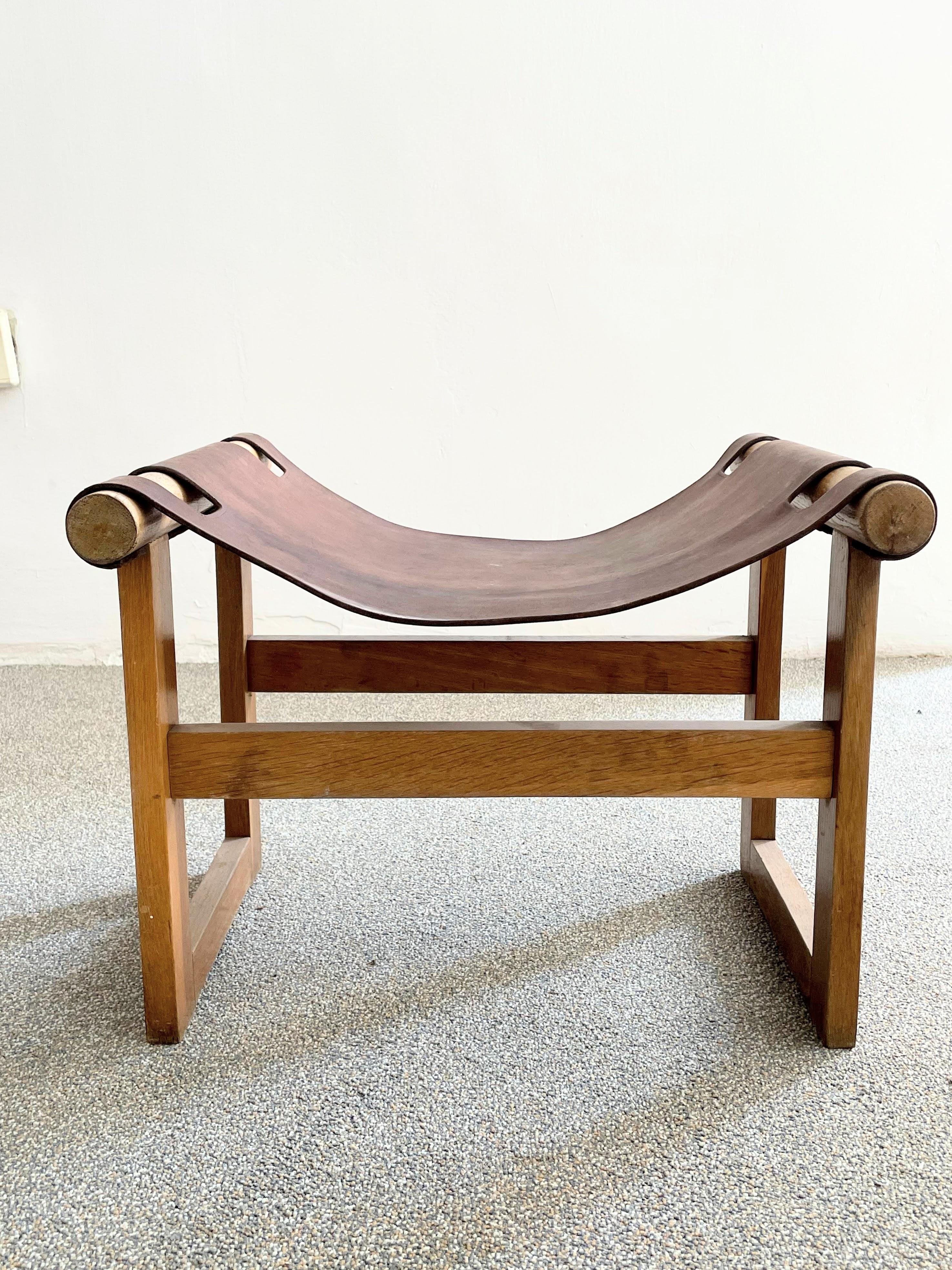 Mid century safari stool with original patinated saddle leather seat.
Absolutely exquisite design with a solid sculptural frame and leather seat. Beautiful solid wood grain and form. In very good vintage condition with only typical light scratches