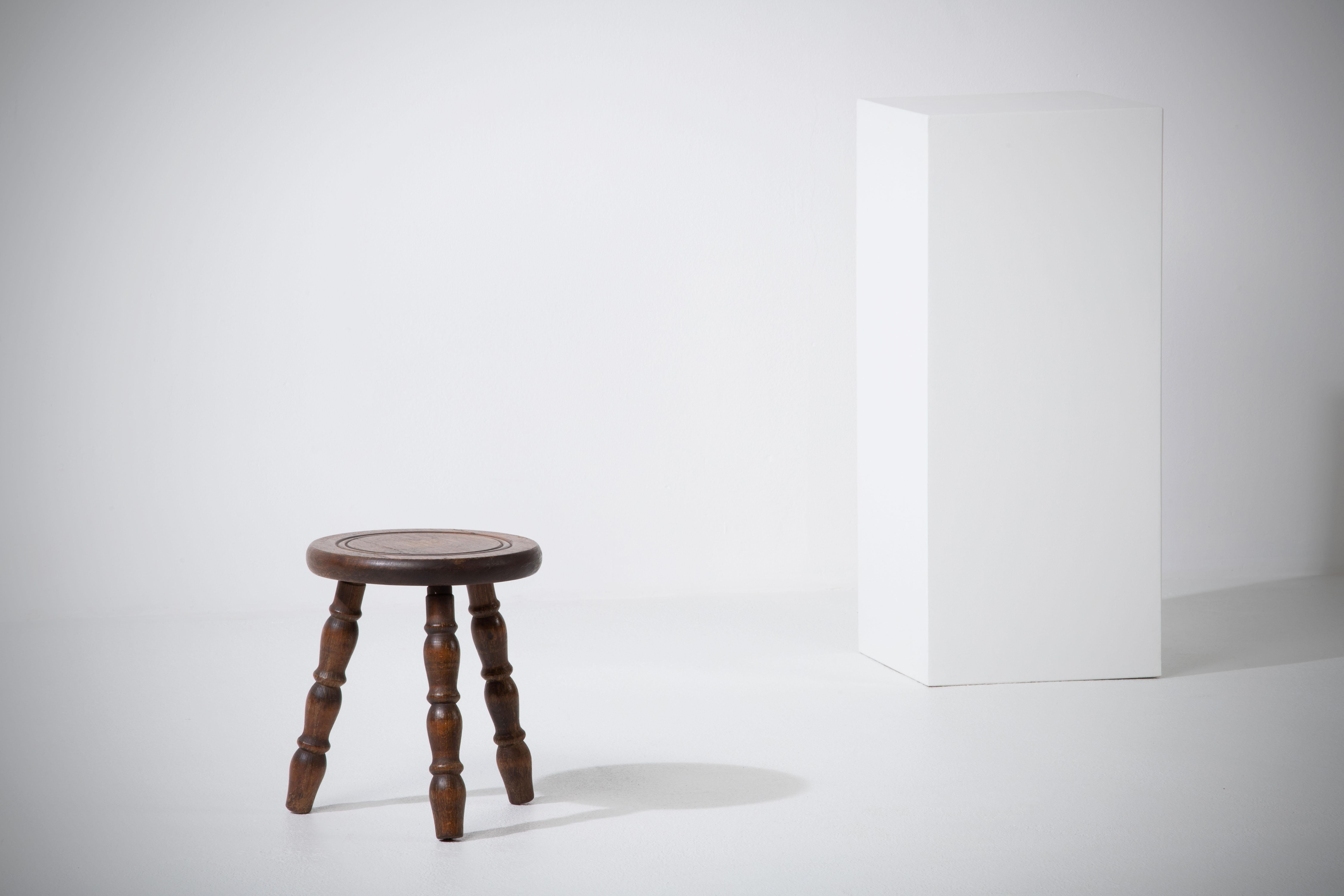 Introducing a fantastic midcentury wooden stool, crafted in France during the 1960s. This piece is constructed without the use of hardware, boasting an elegant round seat and gracefully legs, all made from rich oak wood.

The design is a