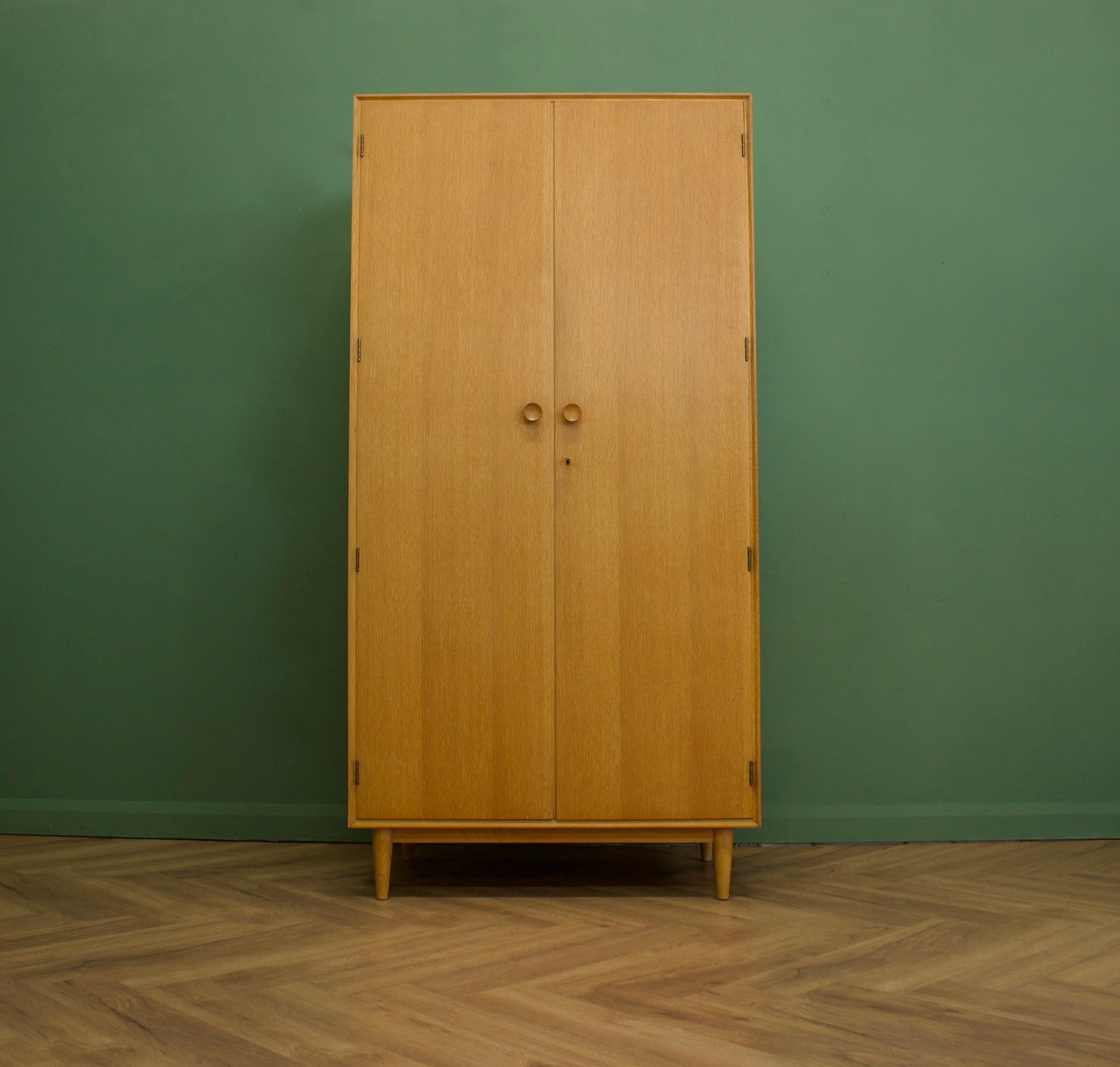 Midcentury wardrobe
Manufactured in the UK by Meredew
Made from oak and oak veneer.

Featuring solid oak handles two rails and a shelf.