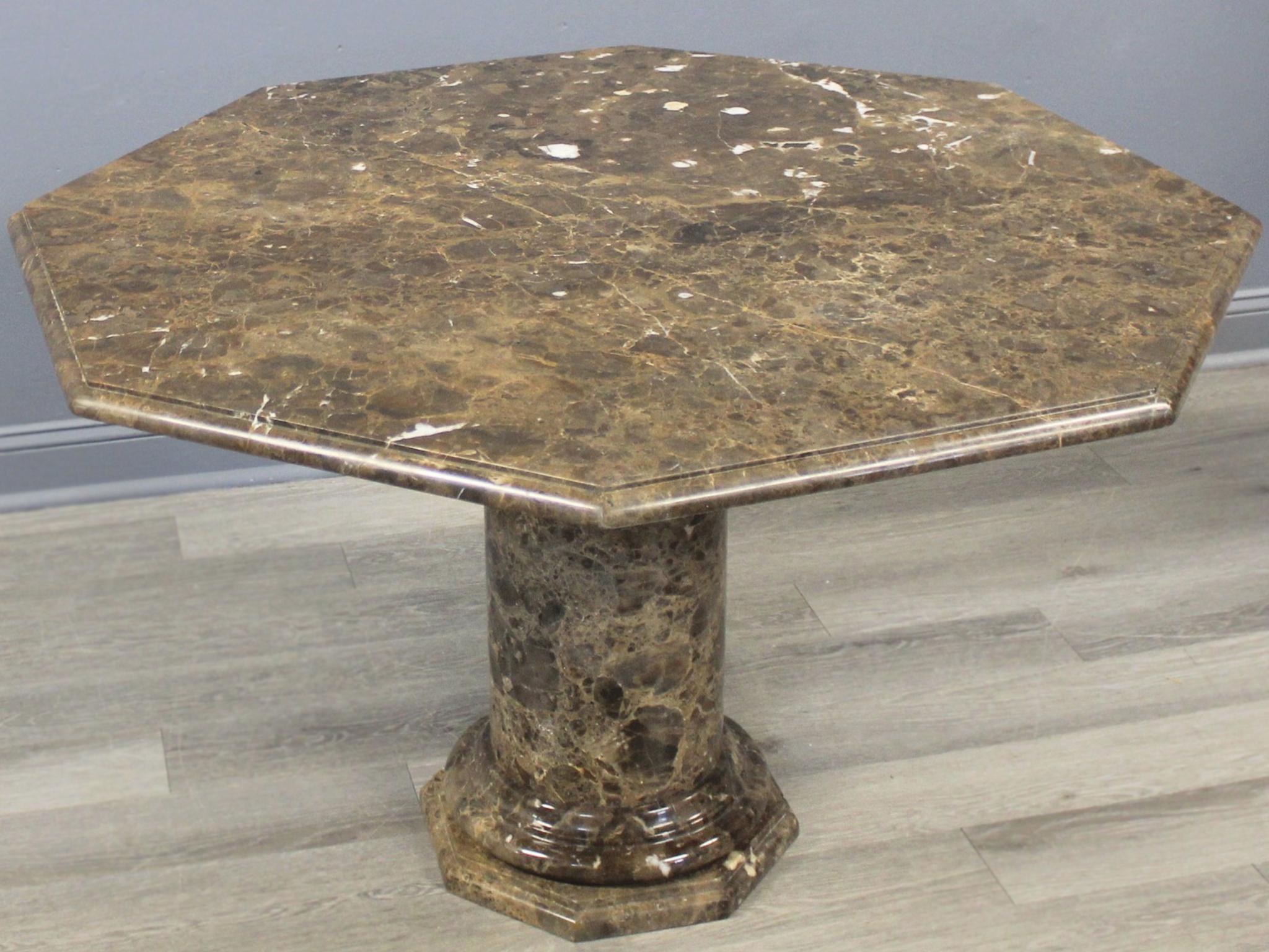 Fabriquée au milieu du XXe siècle en Italie, cette table octogonale en marbre se compose de trois pièces : le plateau, le piédestal et la base. Le plateau présente un élégant bord biseauté qui se retrouve dans le piédestal en forme de colonne et