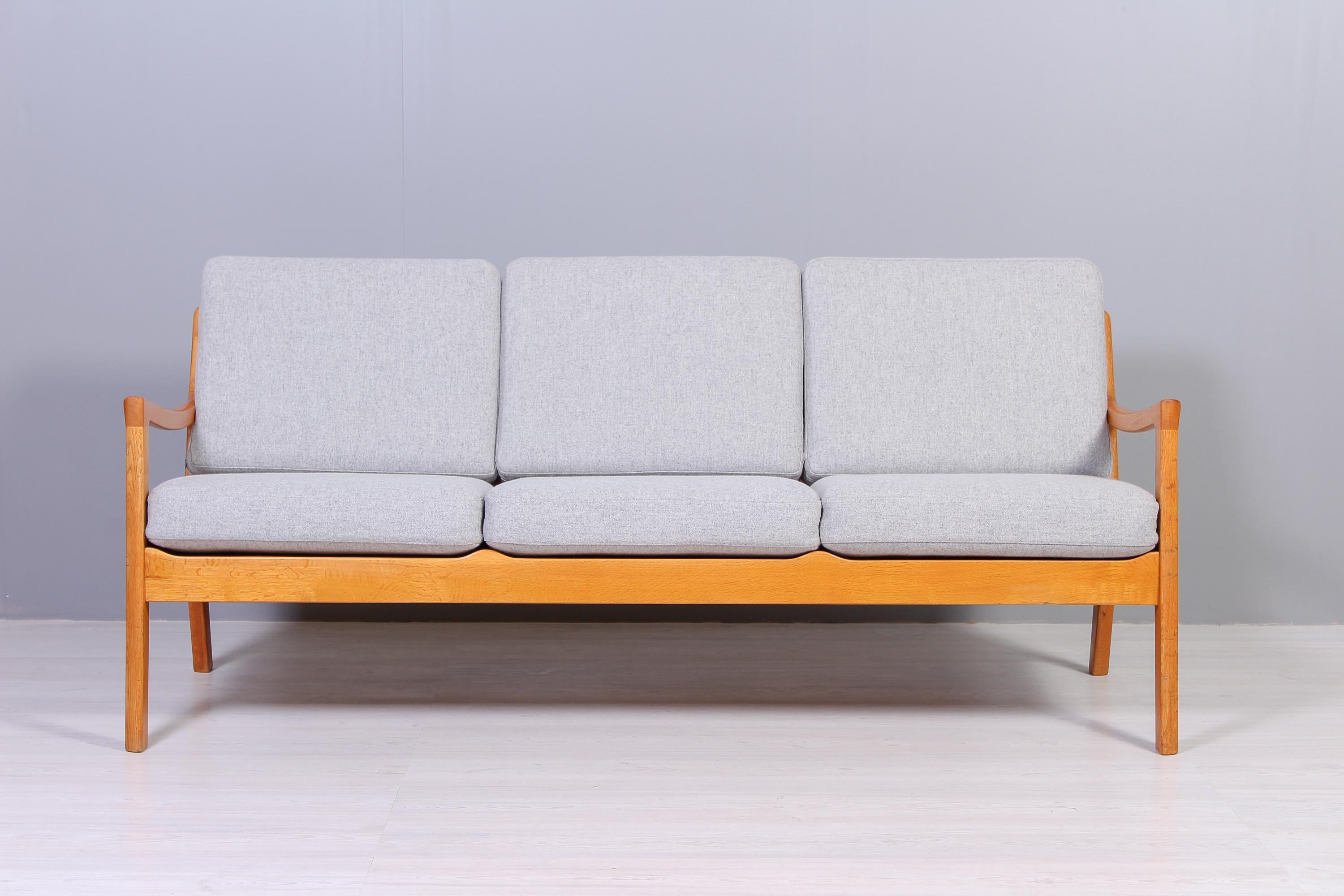 A oak sofa designed by Danish designer Ole Wanscher and produced by Cado in the 1950s. The frame has only light signs of usage and the cushions has been upholstered in a high quality wool fabric.