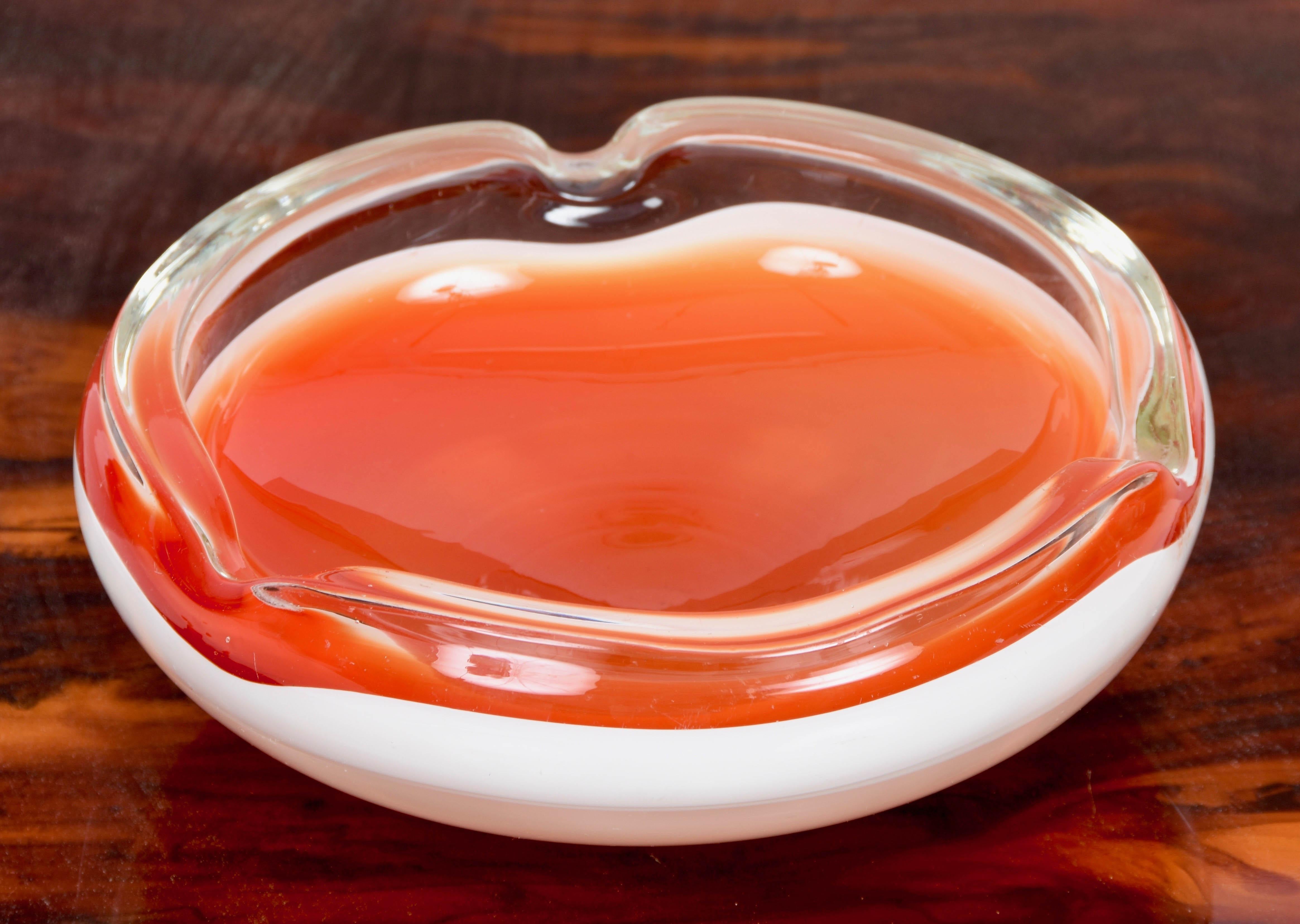 Fantastic midcentury orange and white Murano glass bowl or ashtray. This fantastic piece was designed in Italy during the 1960s.

This piece has a combination of colors, orange and white, that is typical of the 1960s and soft and rounded lines,