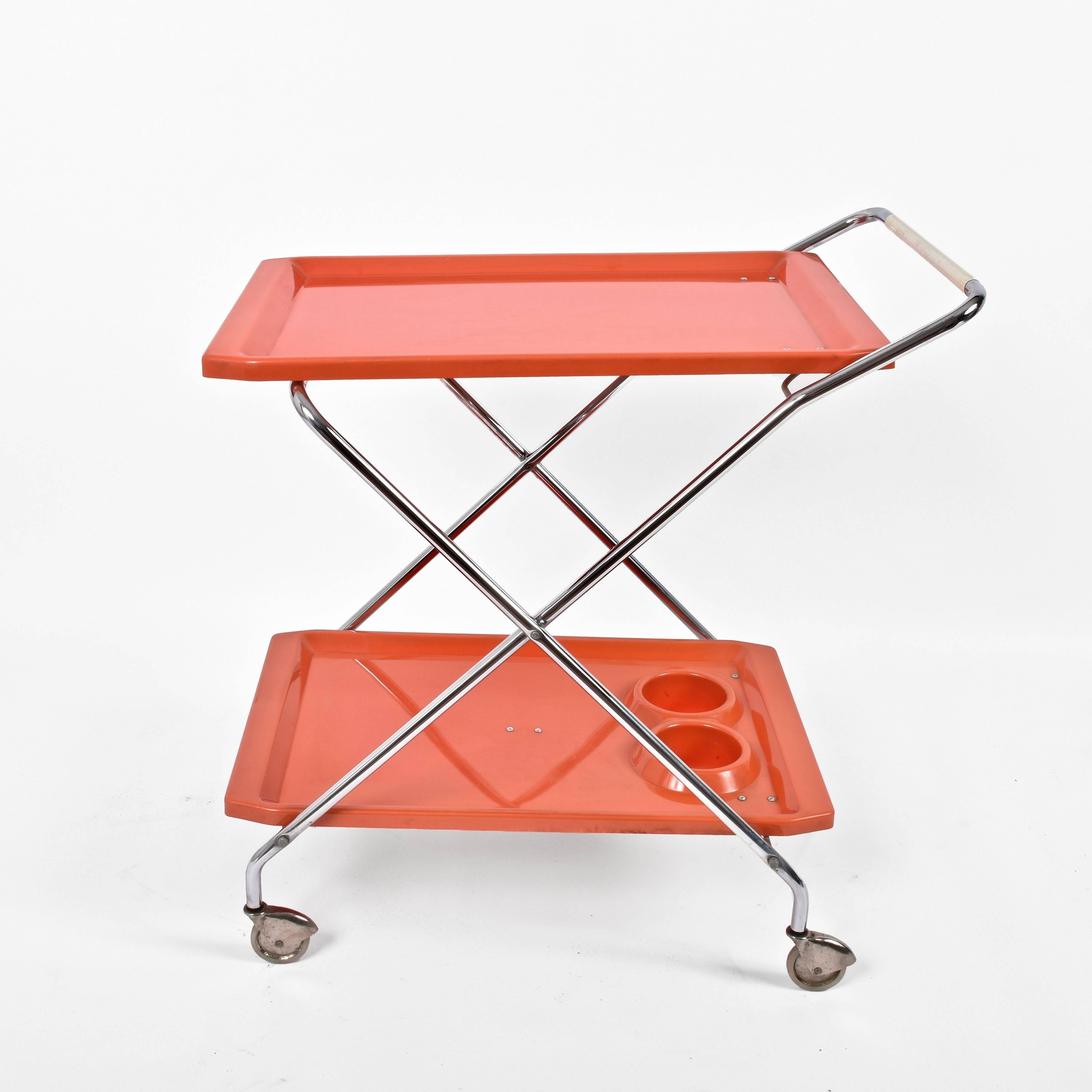 Rare midcentury bar cart in good in very good conditions. This serving table was produced in Italy during the 1950s.

This foldable chrome-plated metal and orange plastic cart represent 1950s Italian design in its essence: pure lines, bold colors