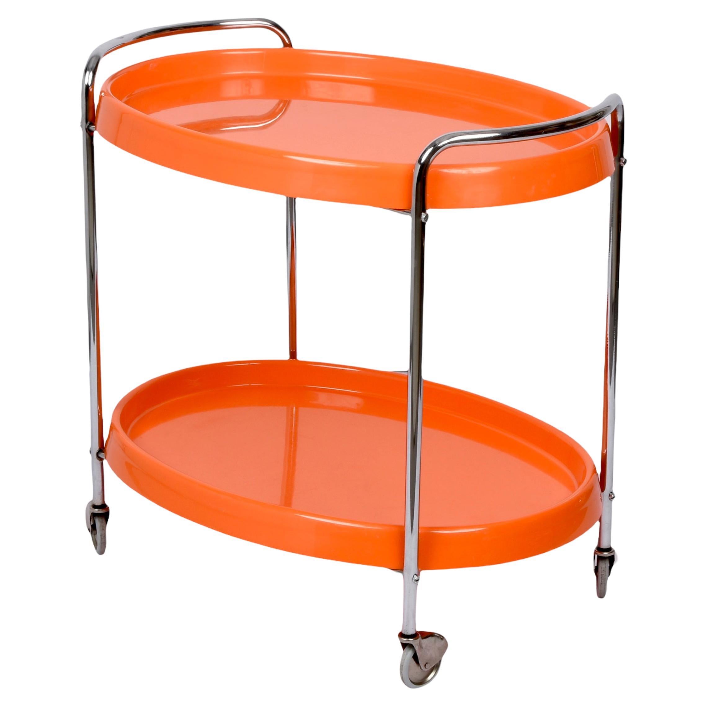 Exclusive Mid Century Orange Plastic & Chrome Metal Oval Bar Cart. This very rare piece was produced in Italy in the 1950s.

This item is in excellent vintage condition and has two oval plastic shelves, a chromed metal frame and four thin, running