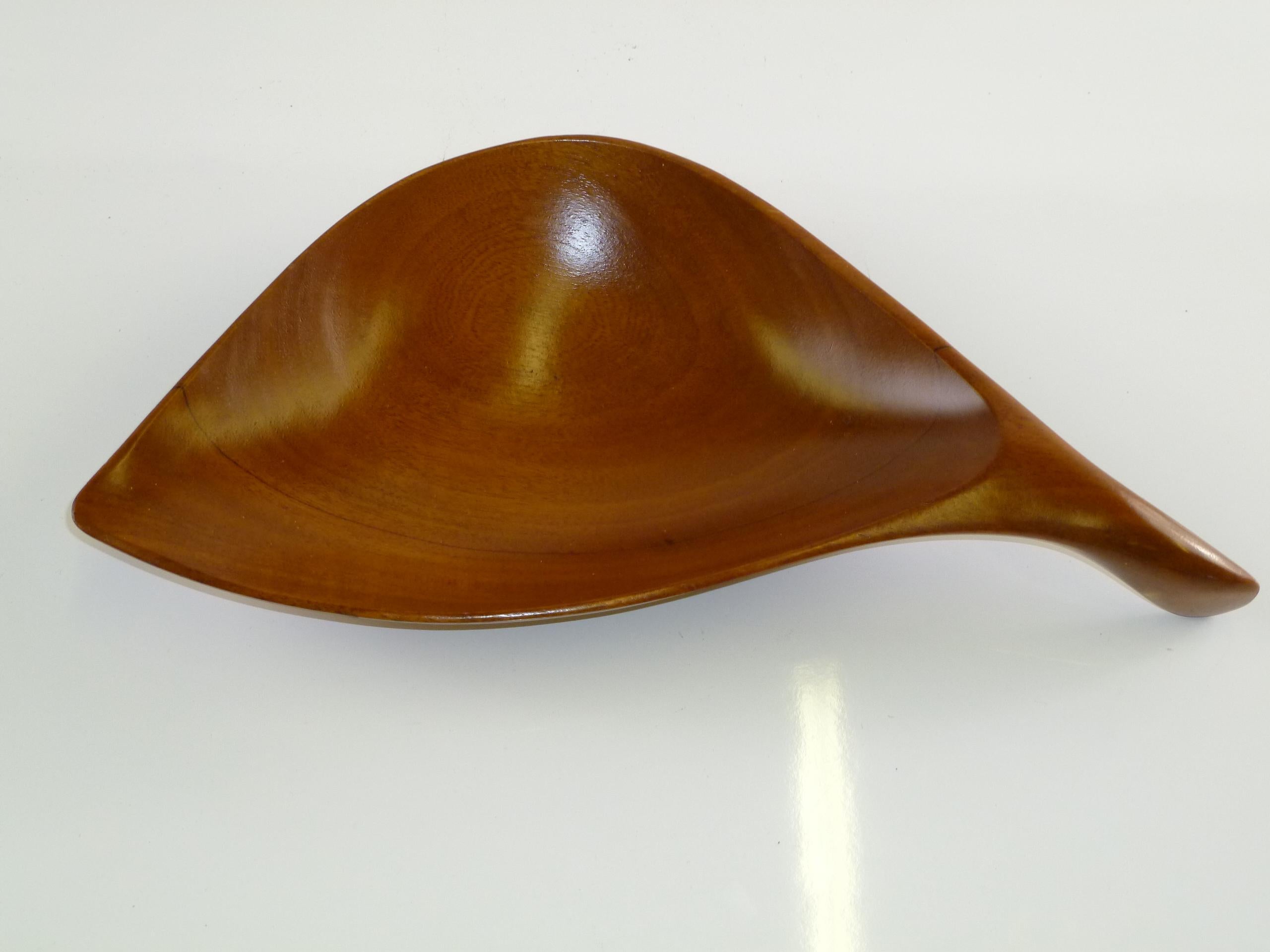 REDUCED FROM $750....Turned and shaped by Emil Milan, a handled leaf shaped bowl made of polished Benin Teak. A wood artist noted for midcentury organic shapes along with known Pennsylvania contemporaries Wharton Esherick and George Nakashima, he