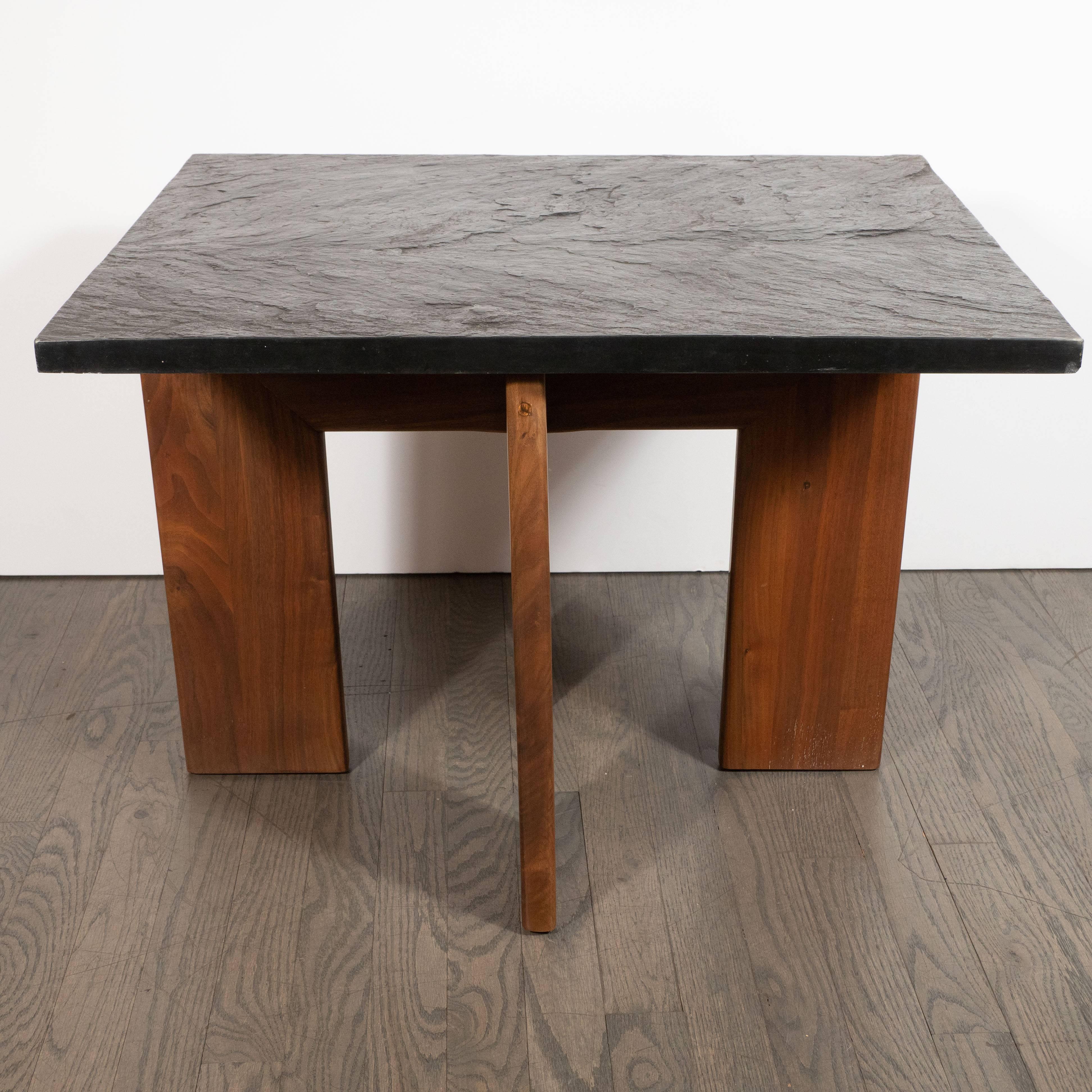 This refined and sophisticated table was realized  by the esteemed designer Adrian Pearsall for Craft Associates in the United States, circa 1960. It features a rectangular slate top resting on four hand rubbed walnut legs that form a right angle at