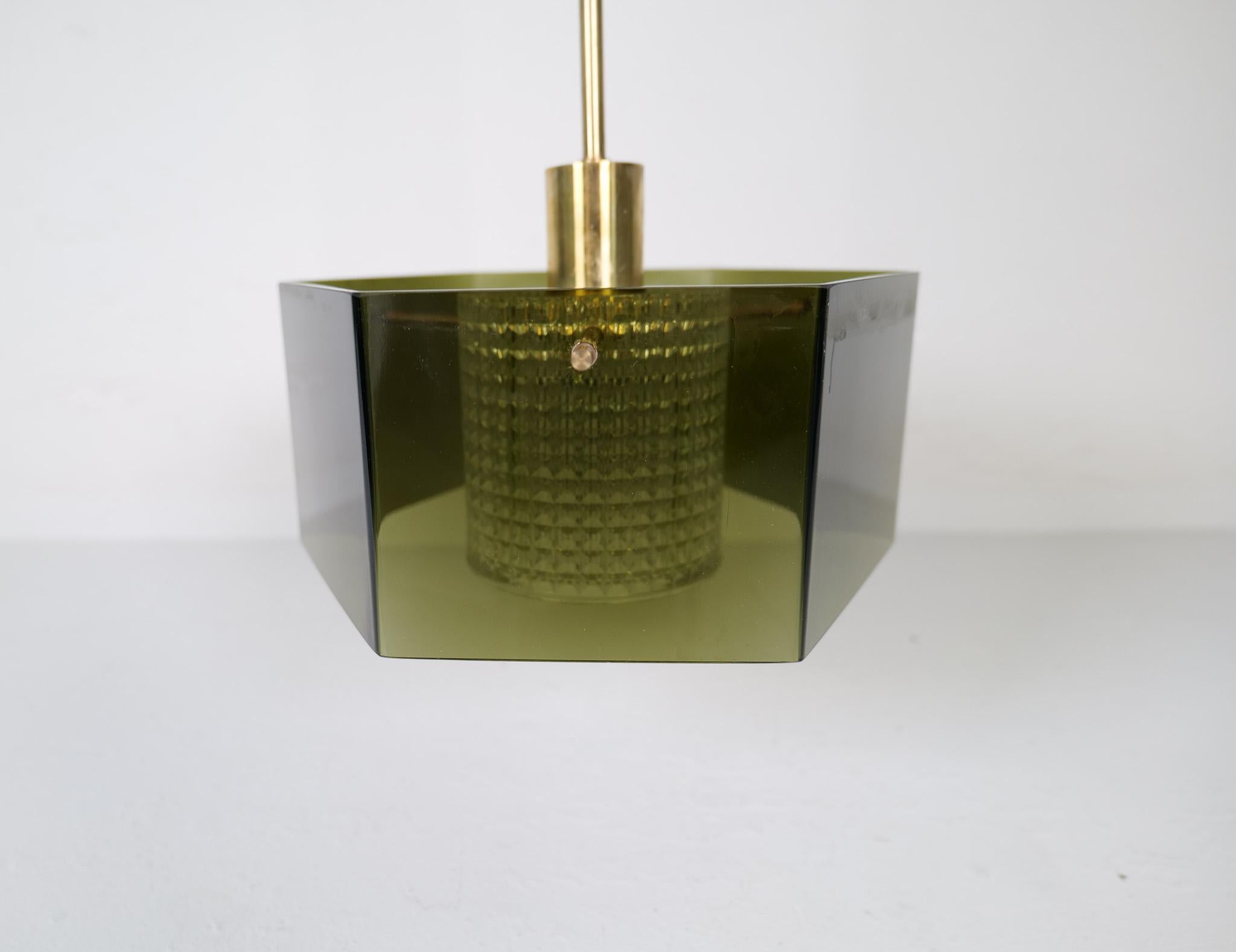 Well-made ceiling light with hand blown green glass. Nice details of brass and clear crystal glass cylinder.
Designed by Carl Fagerlund and manufactured by Orrefors circa 1960s-1970s.

The lamp is in very good vintage condition with minor wear