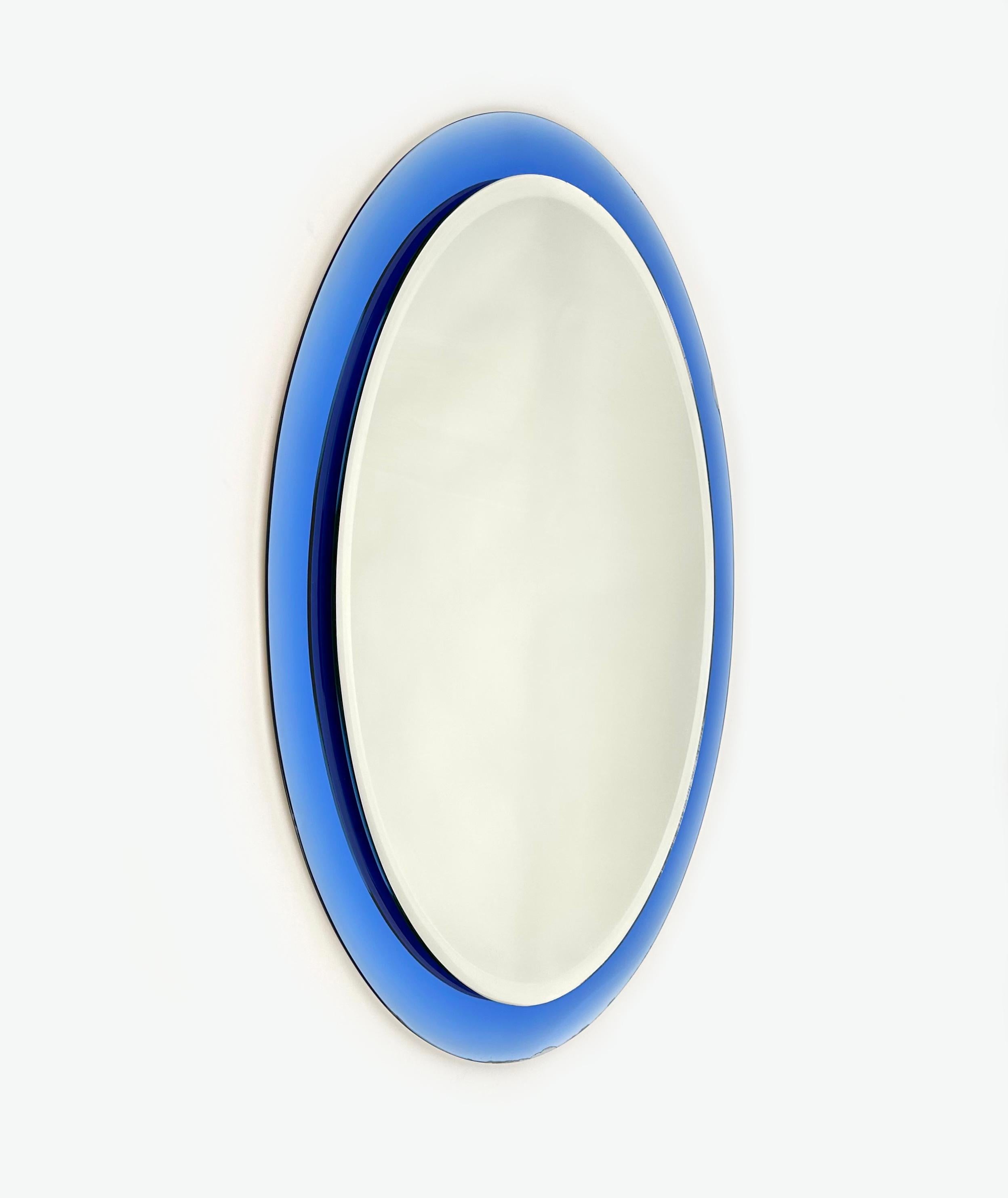 Midcentury Oval wall mirror with blue mirror frame and double decreasing beveled by Metalvetro Galvorame.

Made in Italy in the 1960s.

It comes with its original label signed 