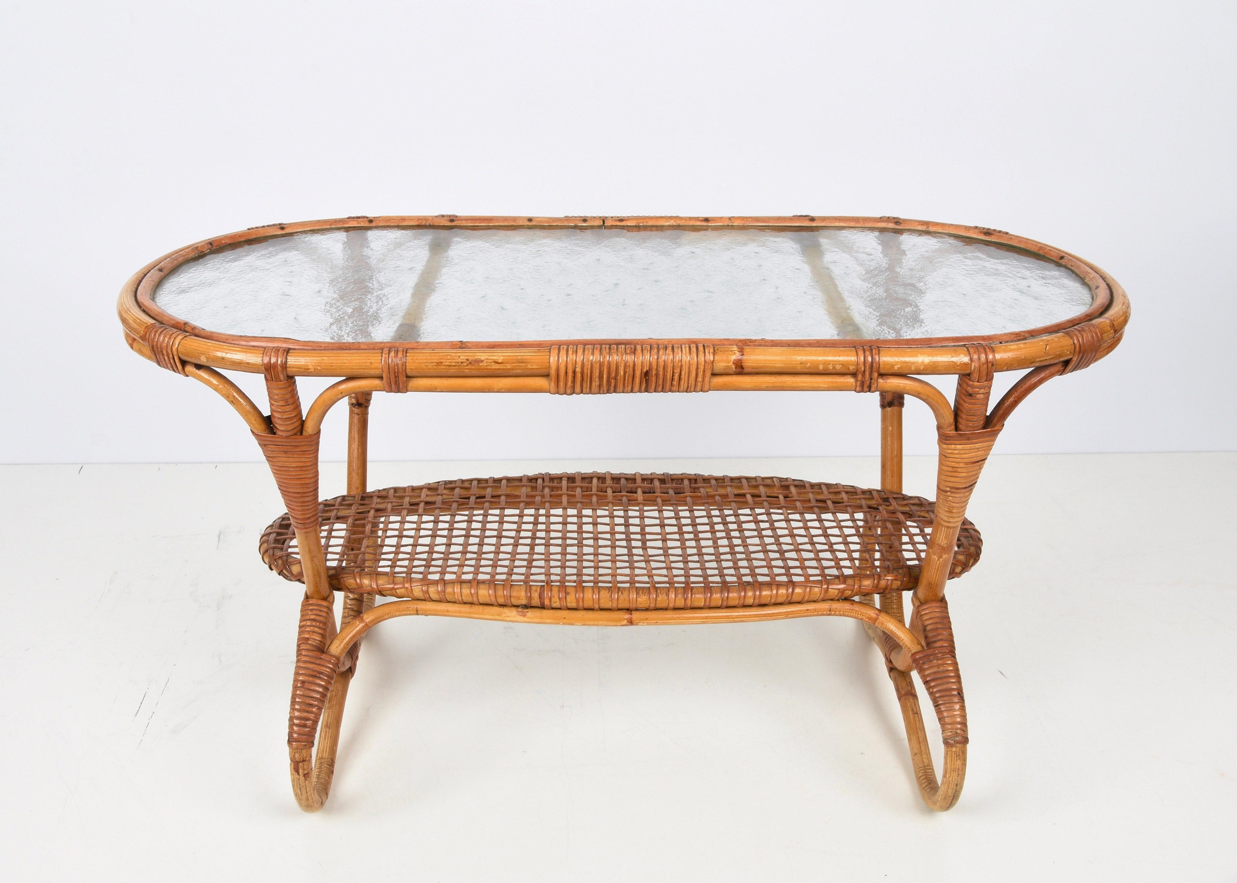 Etonnante table basse ovale en bambou et rotin du milieu du siècle avec plateau en verre. Cet objet fantastique a été conçu aux Pays-Bas par Dirk Van Sliedrecht pour Rohe Noordwolde dans les années 1950.

Cette magnifique table basse est dotée de