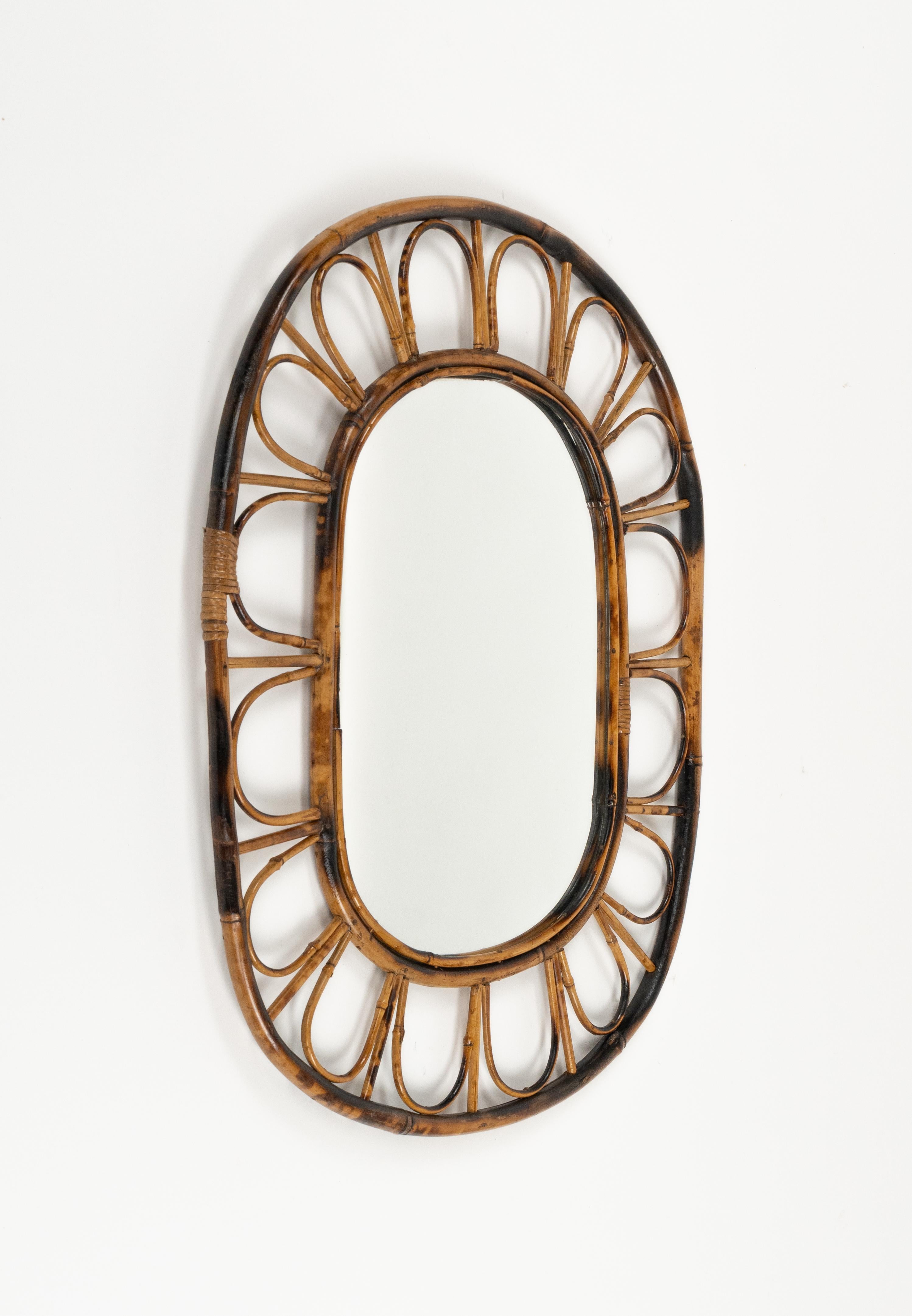Midcentury beautiful oval wall mirror hand-crafted in bamboo and rattan.

Made in Italy in the 1970s.