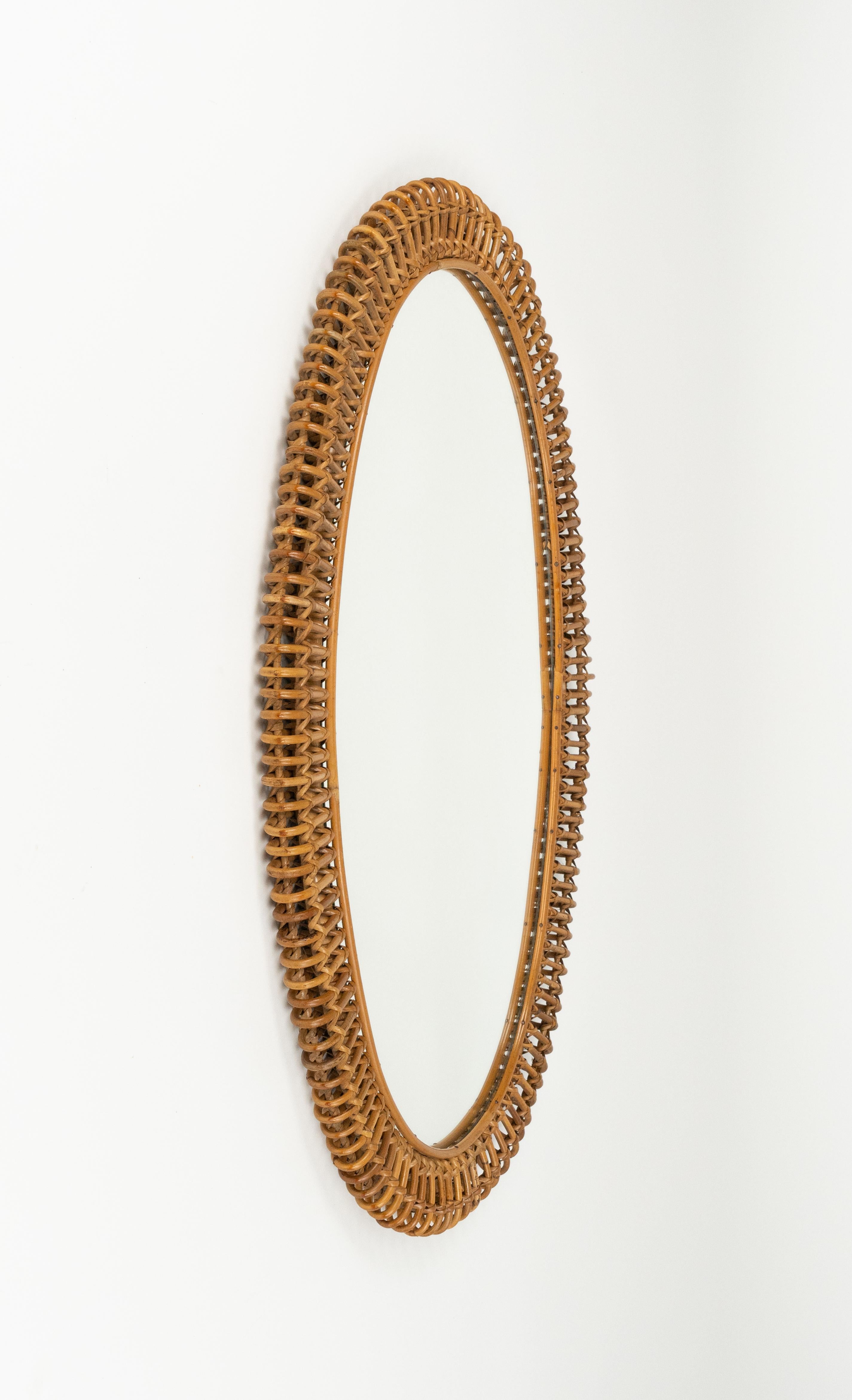Midcentury amazing large oval wall mirror in rattan and bamboo in the style of Franco Albini.

Made in Italy in the 1960s.

A highly decorative bamboo and rattan mirror with the taste of the Mediterranean Coast style.


