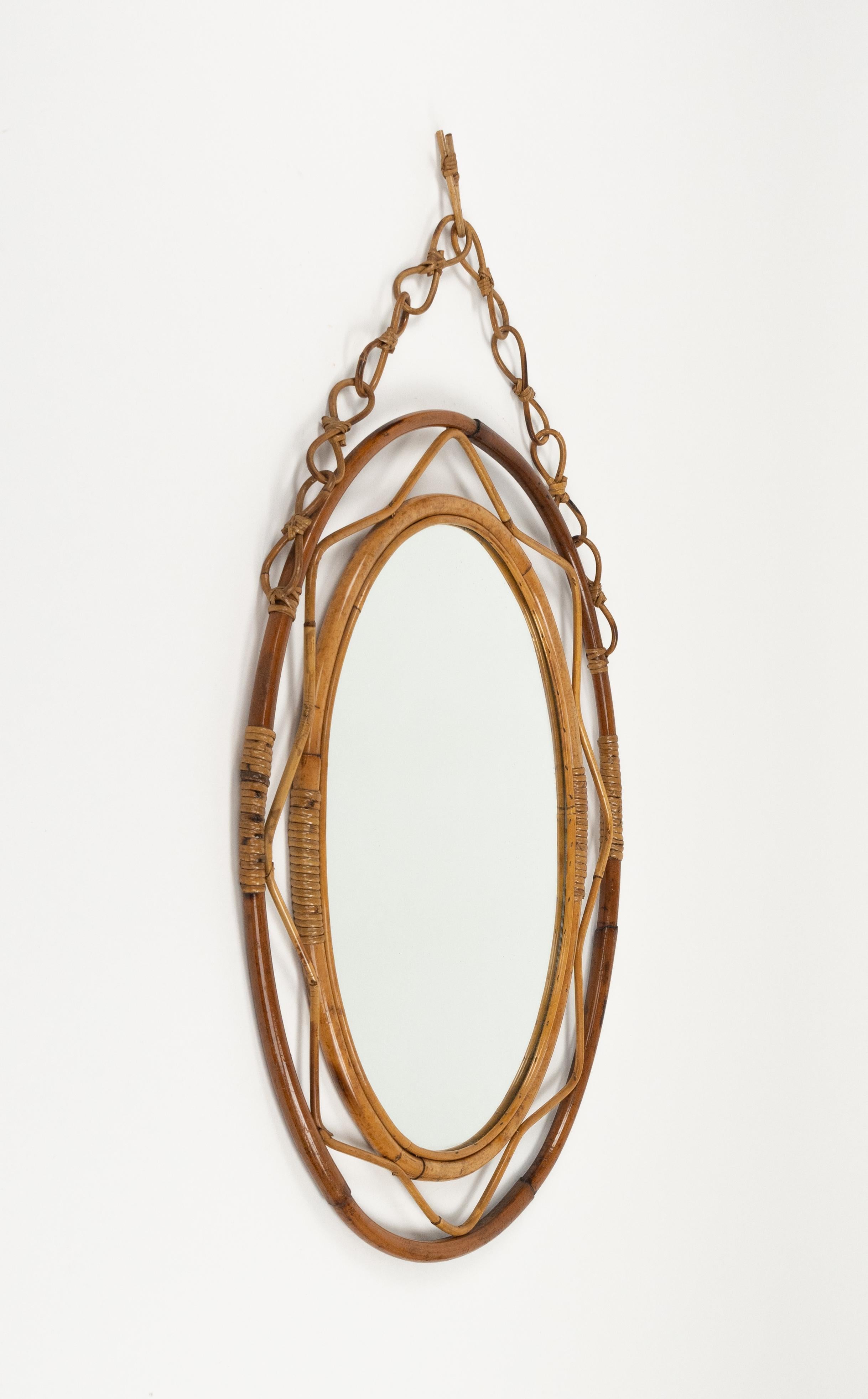 Miroir mural ovale avec chaîne en bambou et rotin.

Fabriqué en Italie dans les années 1960.  

Un miroir très décoratif.  

Dimensions sans chaîne : Hauteur 78 cm.