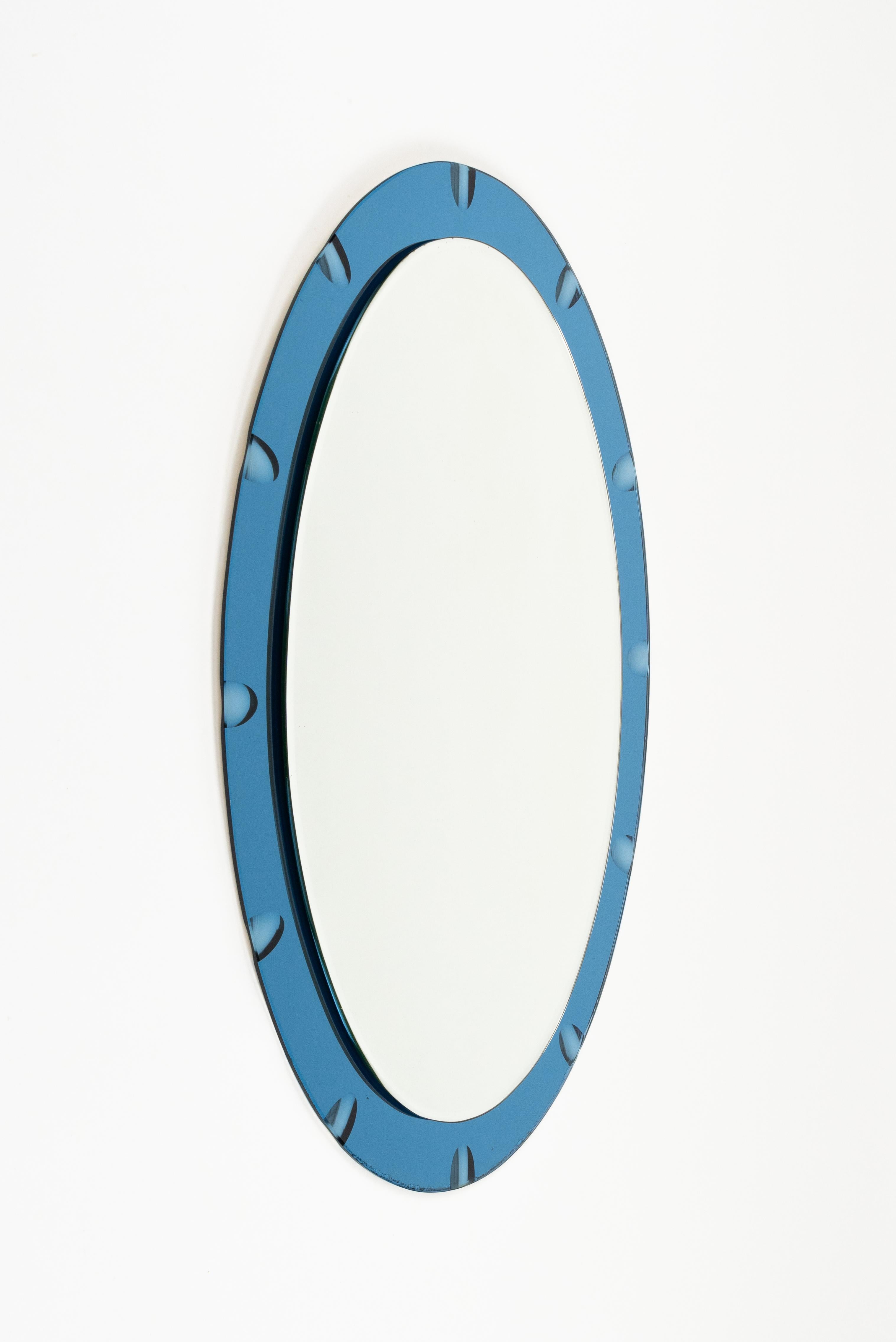 Midcentury amazing oval wall mirror with a blue mirrored border in the style of Crista Arte.   

Made in Italy in the 1970s.   

The mirror, original of the period, shows signs of discolouration.   

The mirror would be perfect for a bedroom,